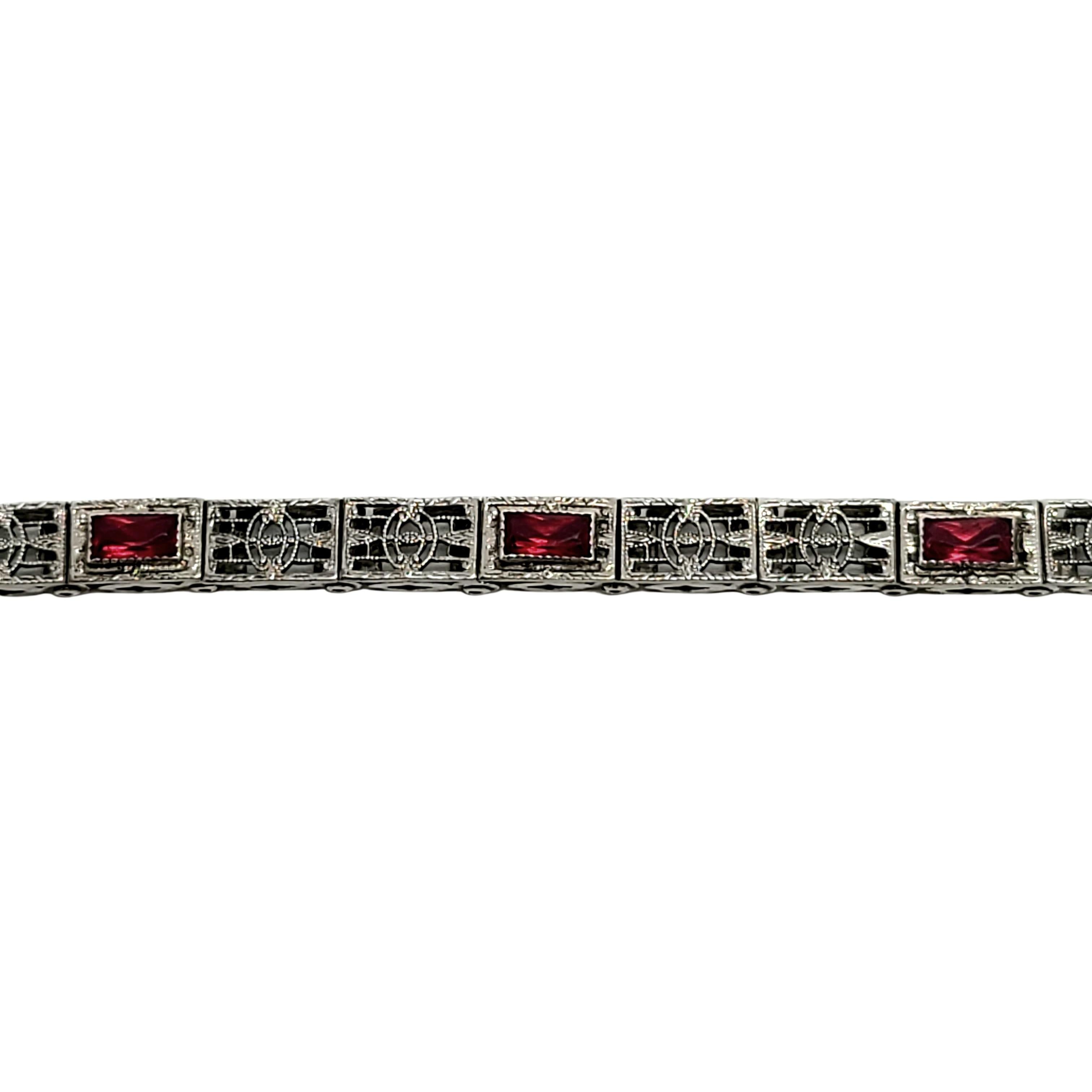 Antique sterling silver filigree panel link bracelet with rectangular red paste stones.

Beautiful and delicate rectangular filigree links, 3 links feature a faceted red paste stone. Push button slide closure with safety clasp.

Measures 6 3/4