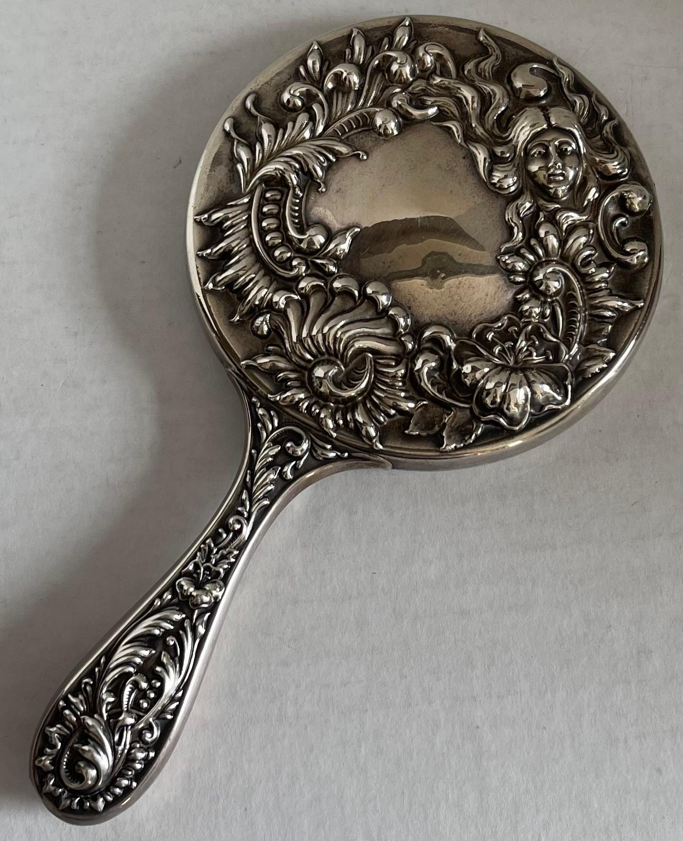 Antique sterling silver repoussè hand mirror. Stamped sterling, as shown in photos. Beveled inset mirror is possibly not original. 