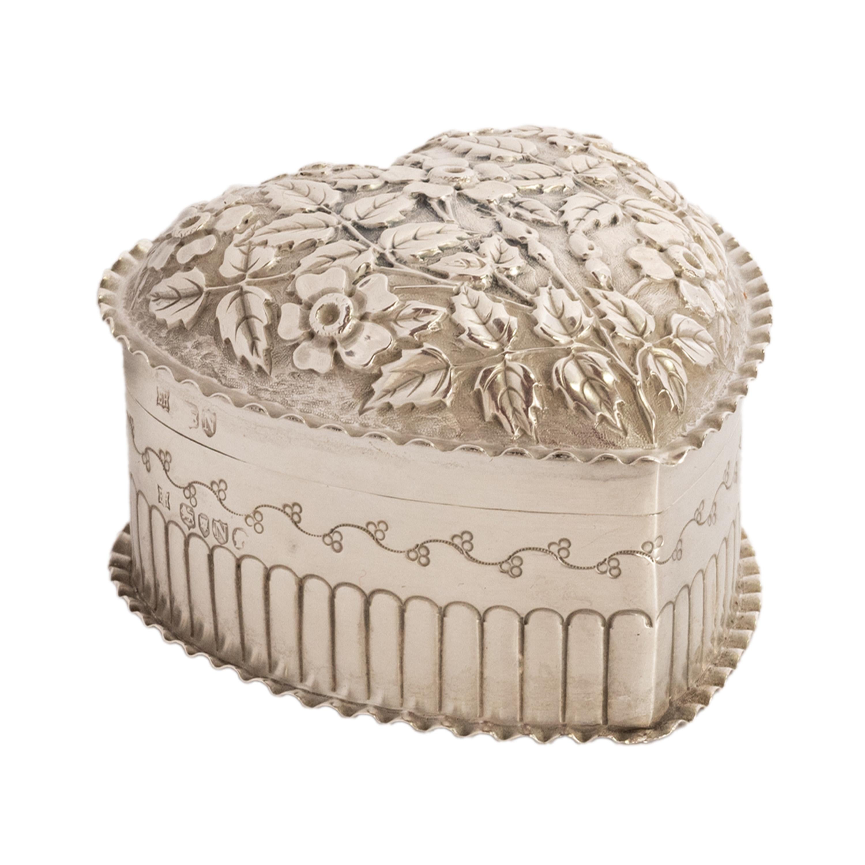 A very elegant antique sterling silver heart shaped trinket/jewelry box, William Hutton & Sons, London, 1888.
The hinged dome topped lid is finely decorated with repousse work flowers and leaves, the edge of the lid having a crimped 'pie crust'