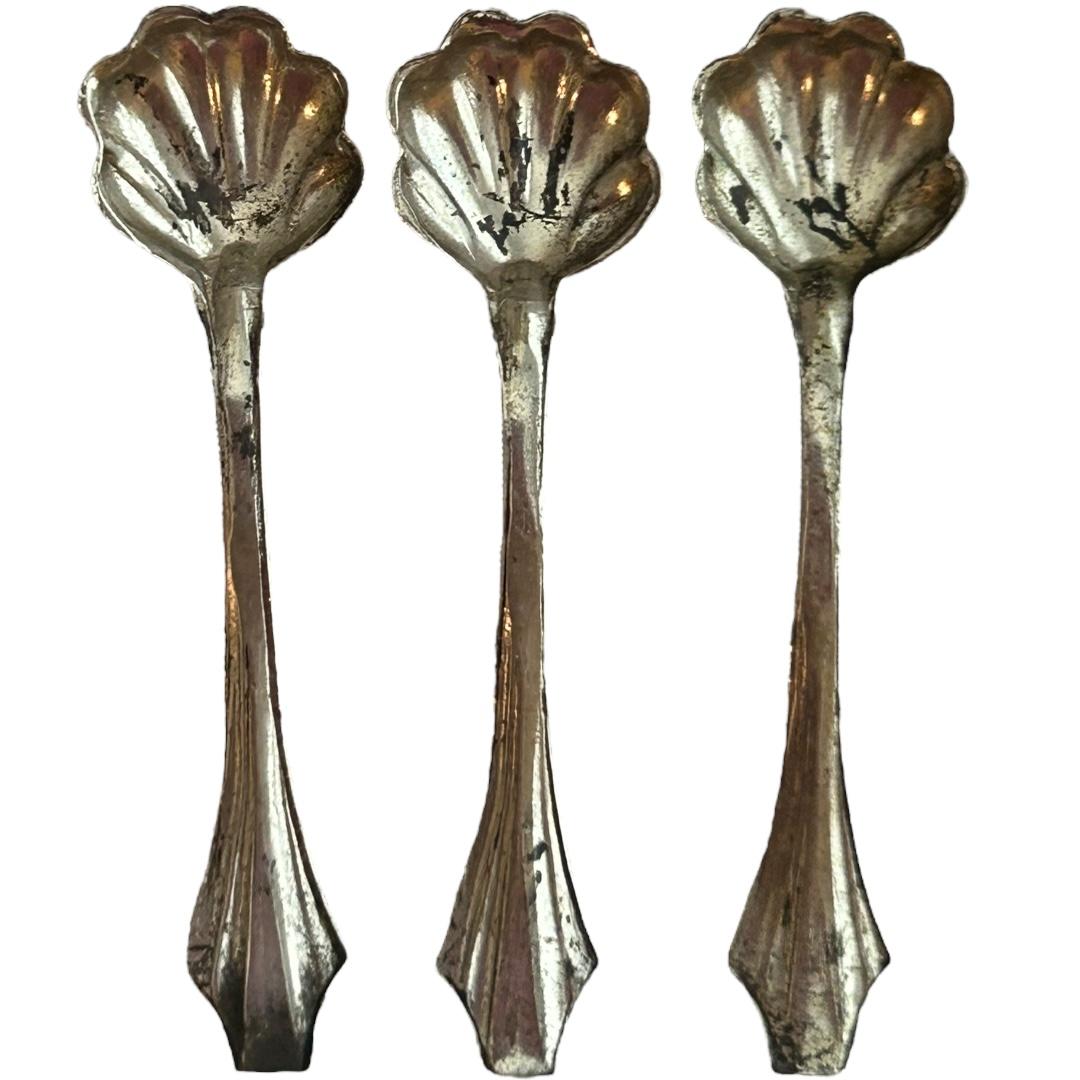 Add a touch of elegance to your dining table with this antique sterling silver salt spoon set.  The intricate ruffled shell pattern adds a unique touch to your table setting.  Crafted from high-quality sterling silver, this spoon set is both durable
