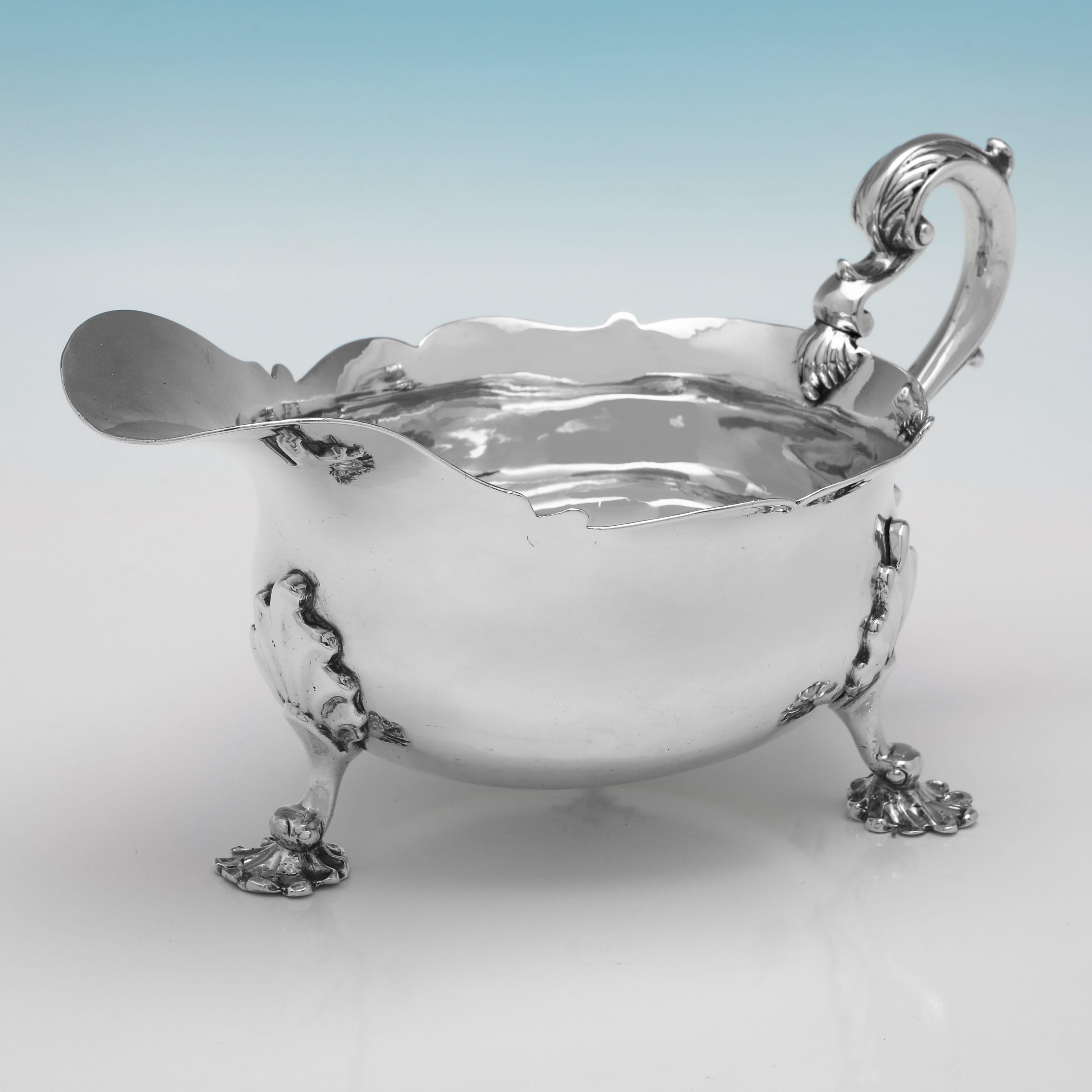Poinçonnée à Londres en 1823 par William Galloway, cette belle saucière ancienne en argent sterling d'époque George IV repose sur trois pieds en fonte et présente une bordure en forme, un écusson de famille gravé et une poignée à acanthe. La