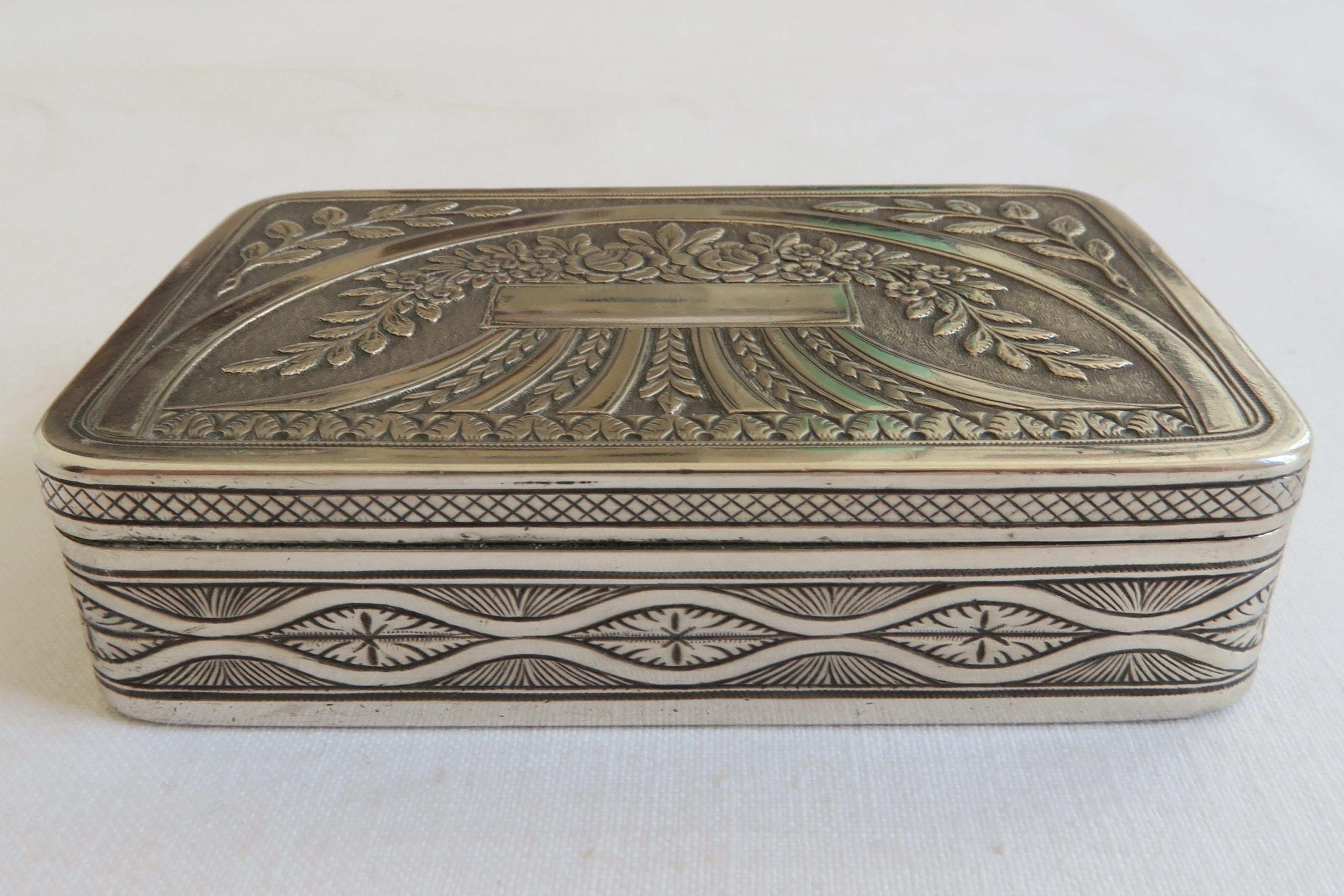 This beautiful snuff box is made from sterling silver. Its inside is gold plated. Lid and bottom are covered in the same floral design reminiscent of a bouquet or floral ornament. The box is stamped with the Austrian import Hallmark. Made ca.