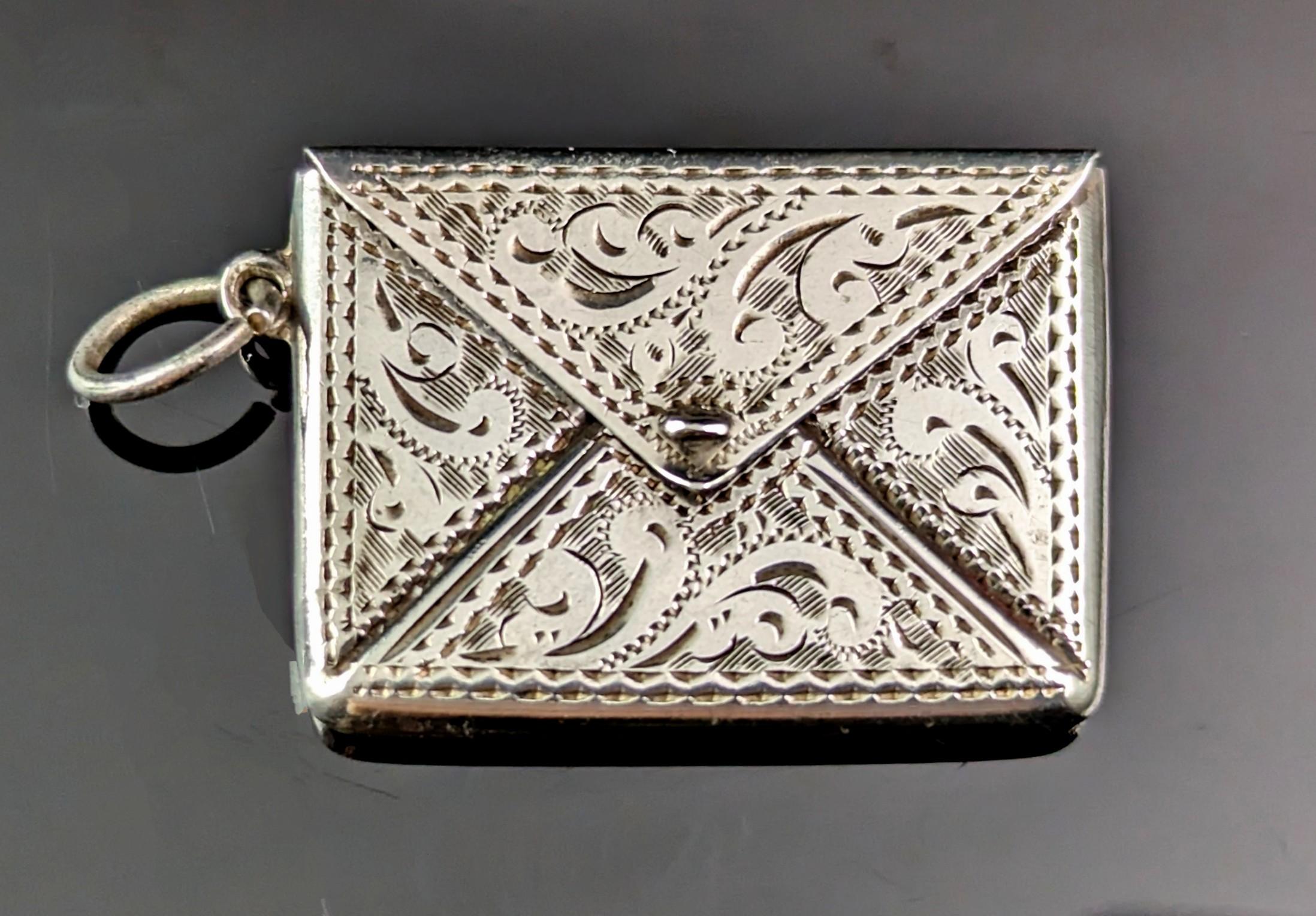 Such a charming and attractive antique sterling silver stamp case pendant.

This pretty stamp case is designed as an envelope with a small compartment for holding postage stamps, these are such wonderful little pieces full of character and