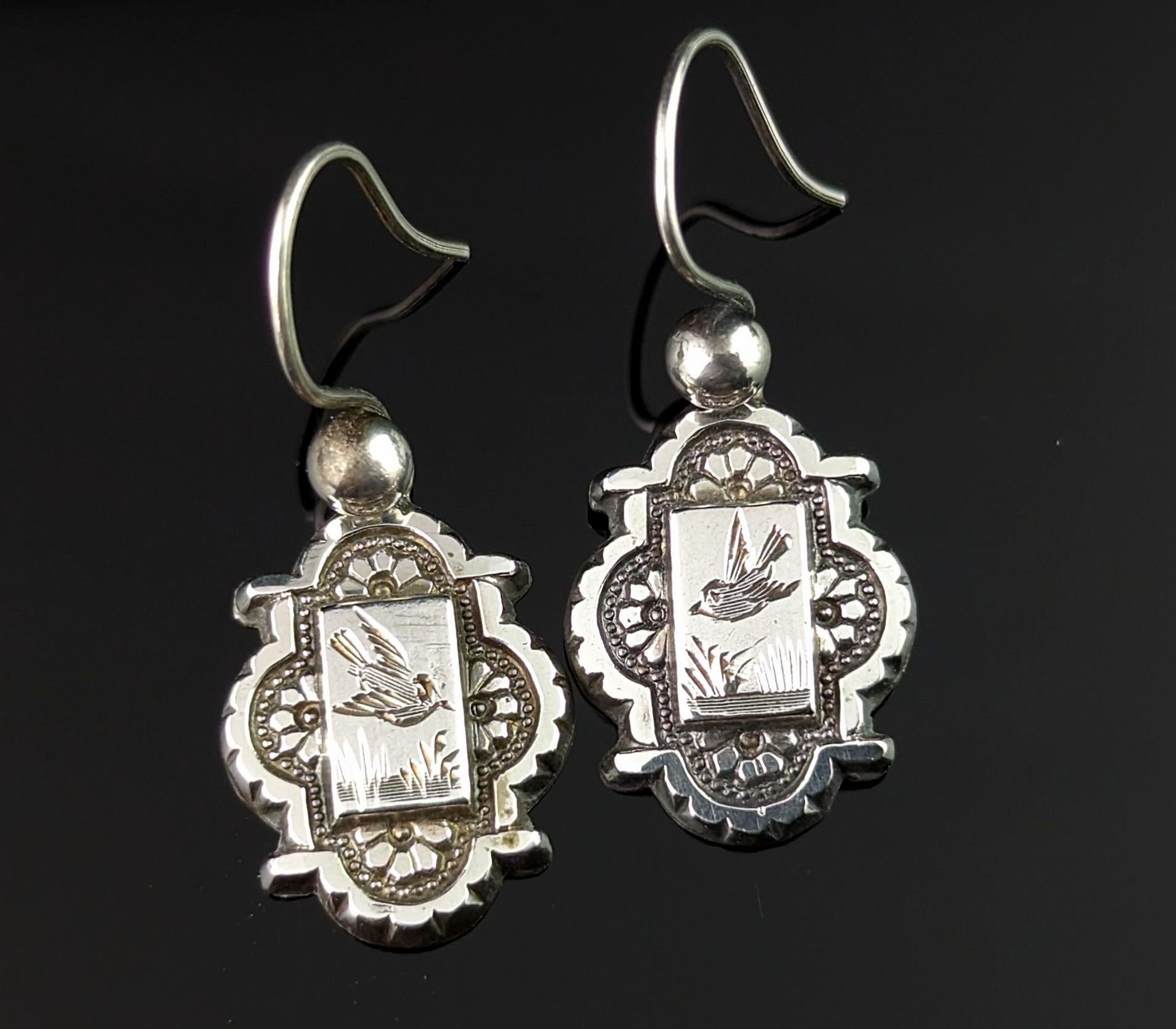 A sweet pair of Victorian sterling silver swallow earrings.

These ooze aesthetic style and are an oval shape with engraved central designs of swallows in flight with little repousse floral designs to the outer edges.

So much detail in this prerty
