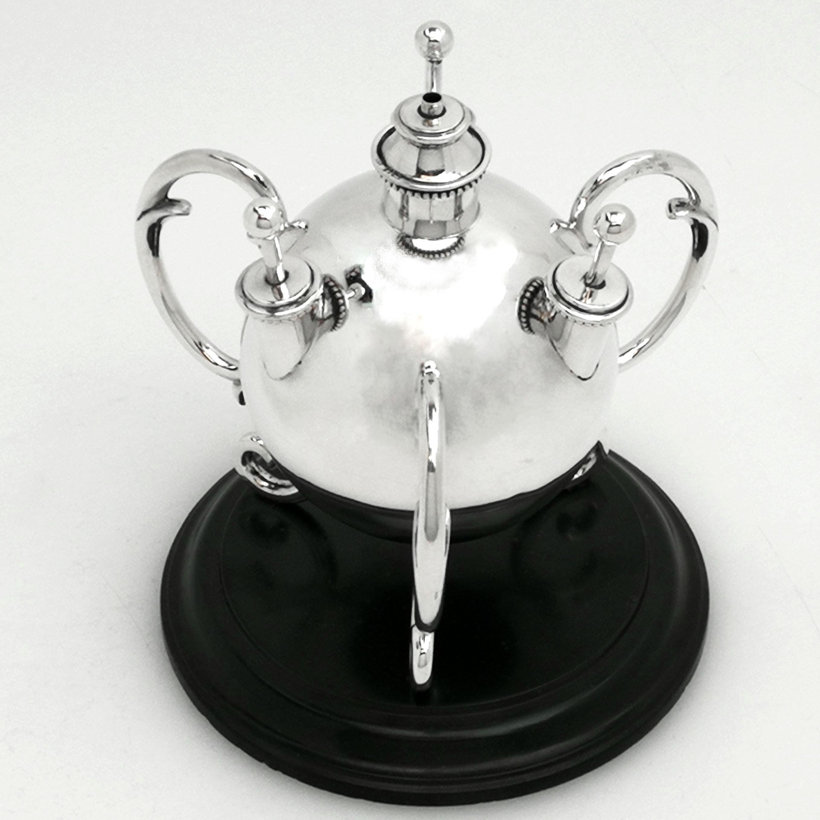 An exceptional antique Edwardian solid Silver Table Lighter on a black stone plinth. This ball shaped Table Lighter is supported on three double scroll feet. The Lighter has a central burner and three individual removable wands as lighters that can