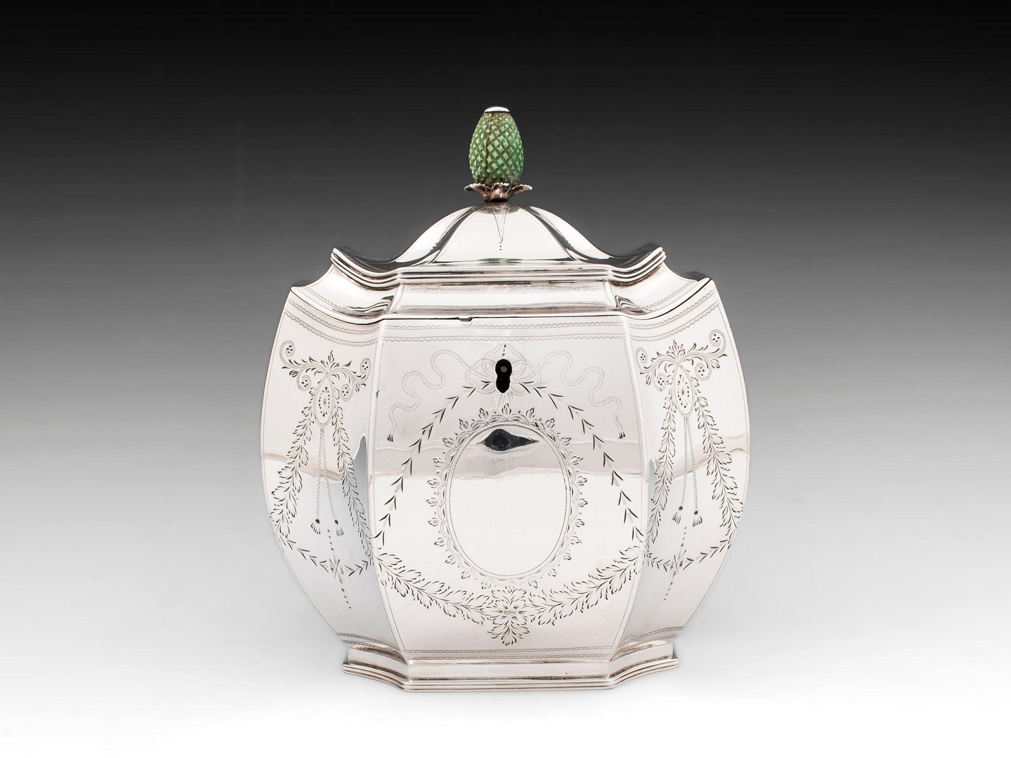 Wonderful bombe shape sterling silver tea caddy, with a green-stained bone handle in the form of a pineapple.
The body of the caddy is decorated with engraved floral garlands, swags and ribbons. The hinged lid opens to reveal a single divider