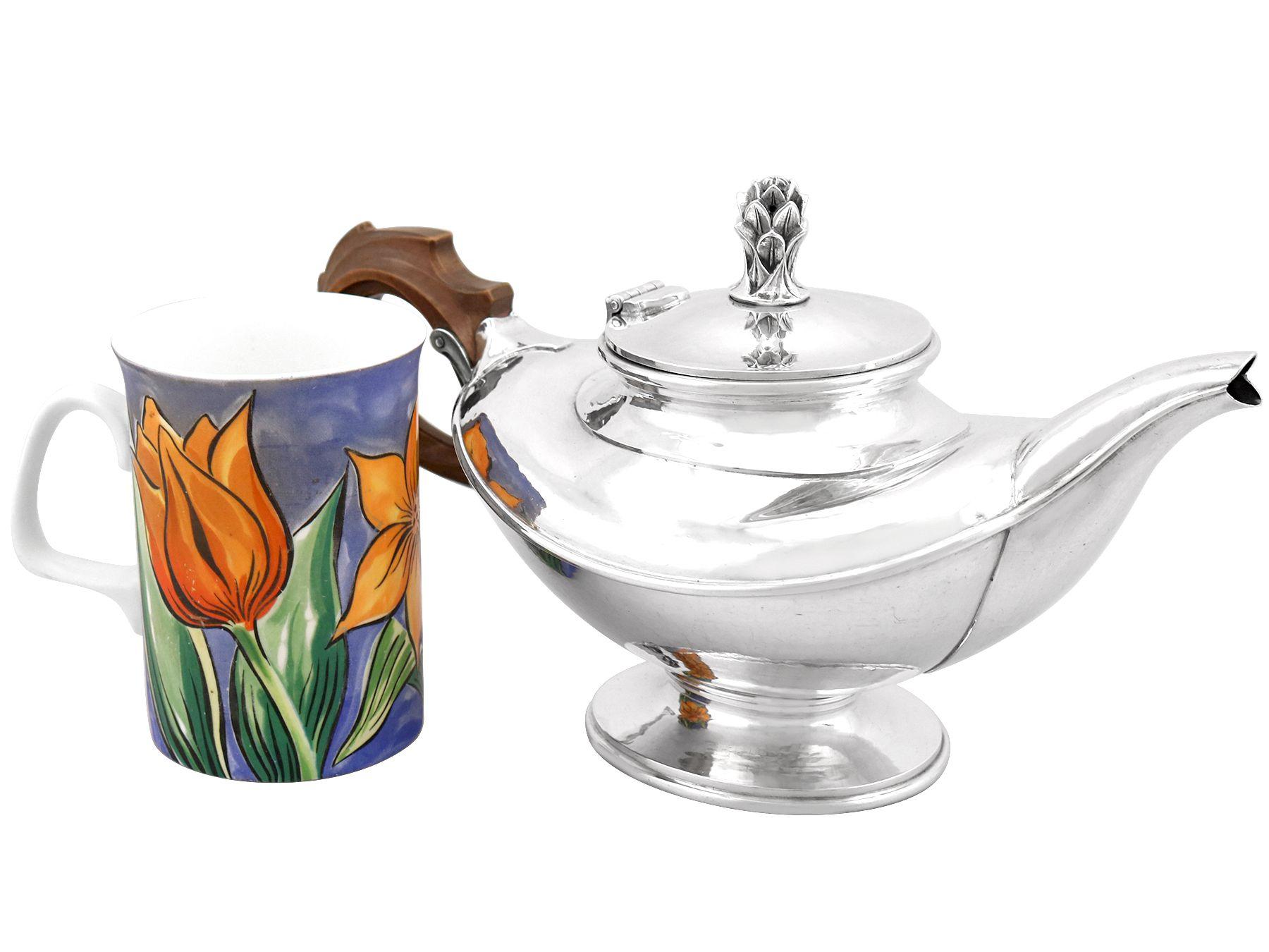 An exceptional, fine and impressive antique George V English sterling silver teapot made by Omar Ramsden; an addition to our collectable silver teaware collection.

This exceptional antique George V English sterling silver teapot has an oval boat
