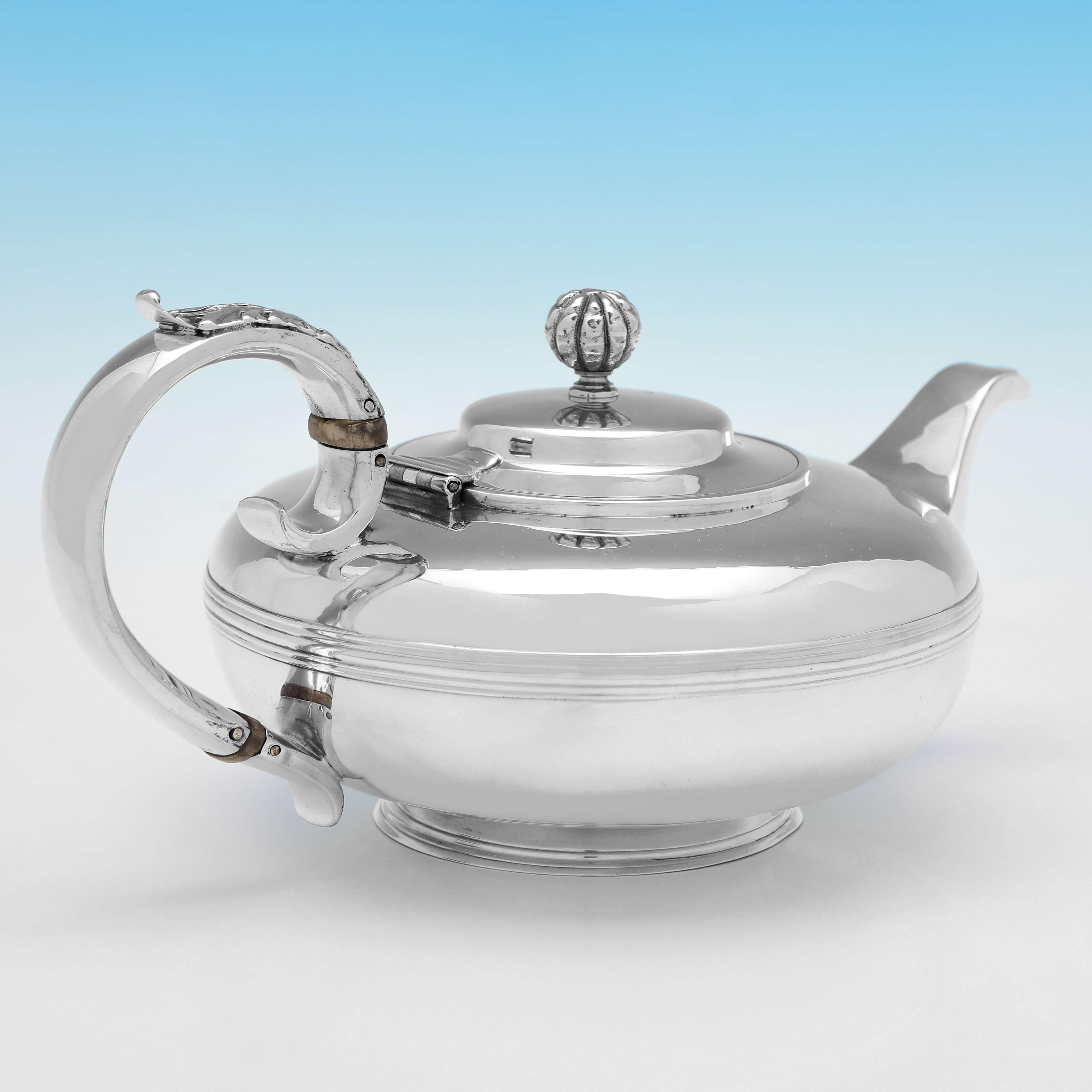 Hallmarked in London in 1830 by Thomas Johnson, this handsome, George IV period, Antique Sterling Silver Teapot, is plain in design and round in shape, with reed borders, a pumpkin finial, and acanthus detailing to the handle. 

The teapot measures