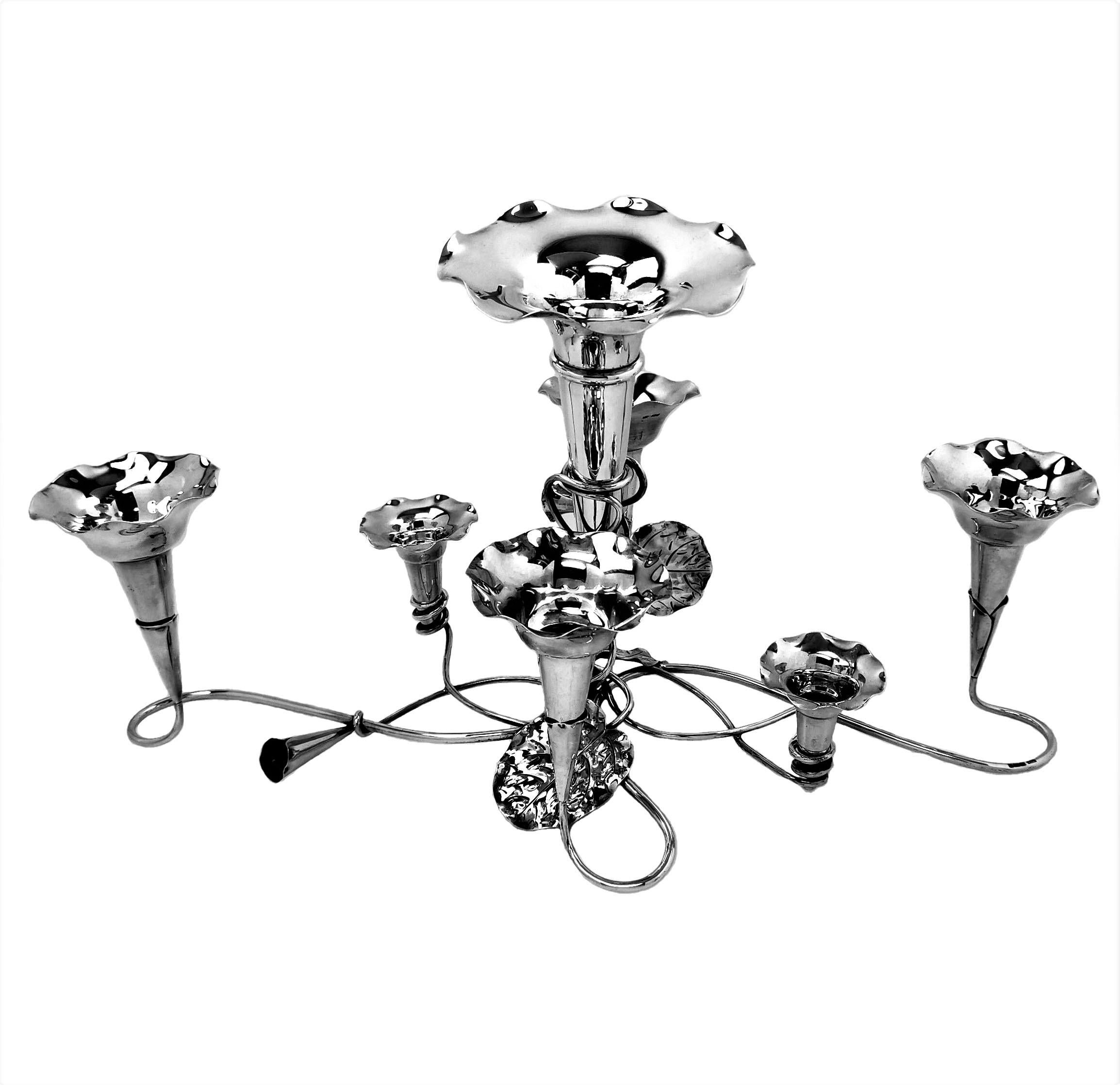 A beautiful Antique solid Silver Epergne in an elegant trailing flower design with 7 trumpet Vases arranged as stylised flowers on the branches of the centrepiece. 

Made in Sheffield, England in 1910 by Mappin & Webb.

Approx. Weight - 1112g /