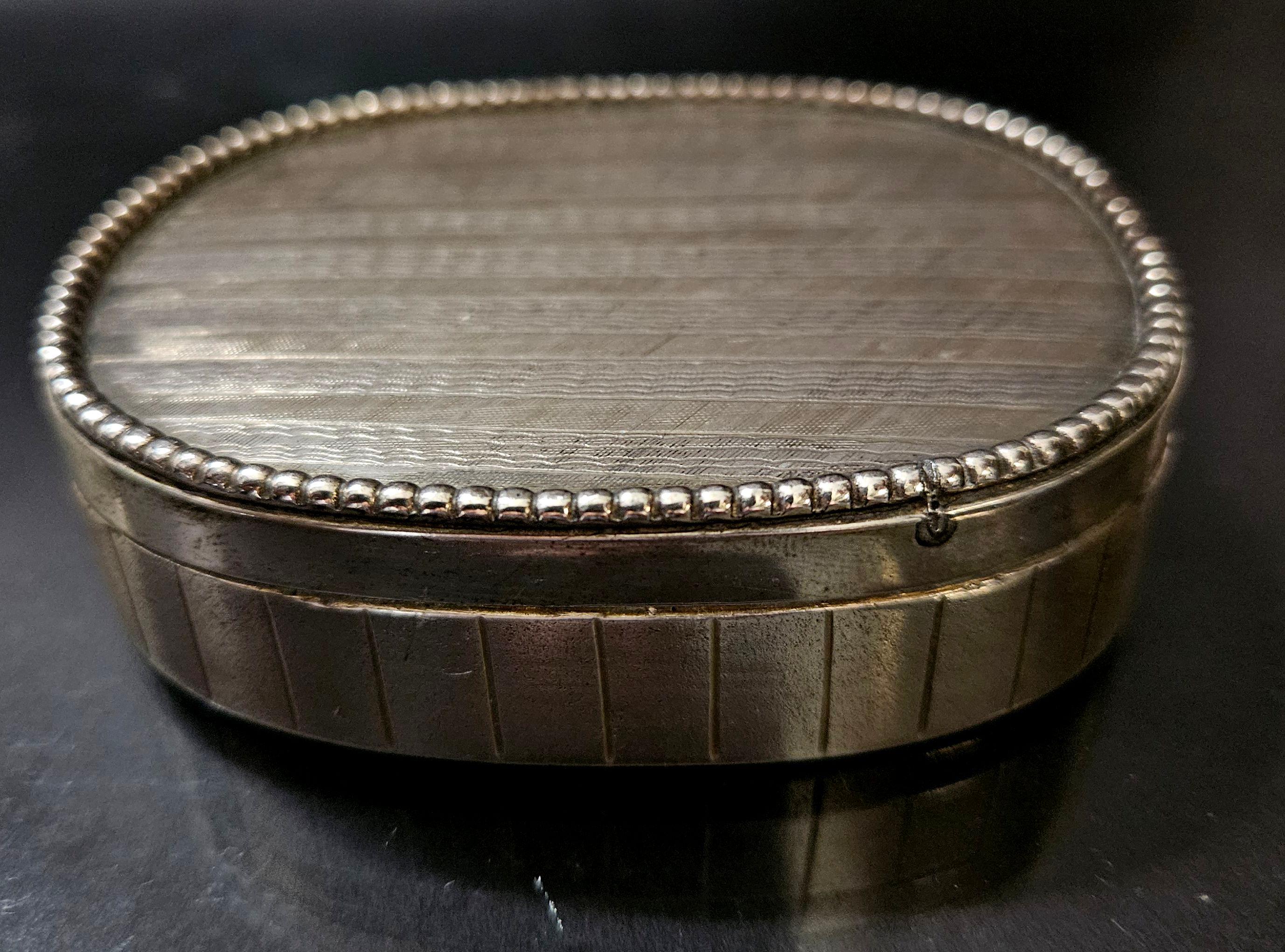 An 19th-century sterling silver snuff trinket box with engine-turned engraving to the hinged lid,  brightly gilded interior with the character 