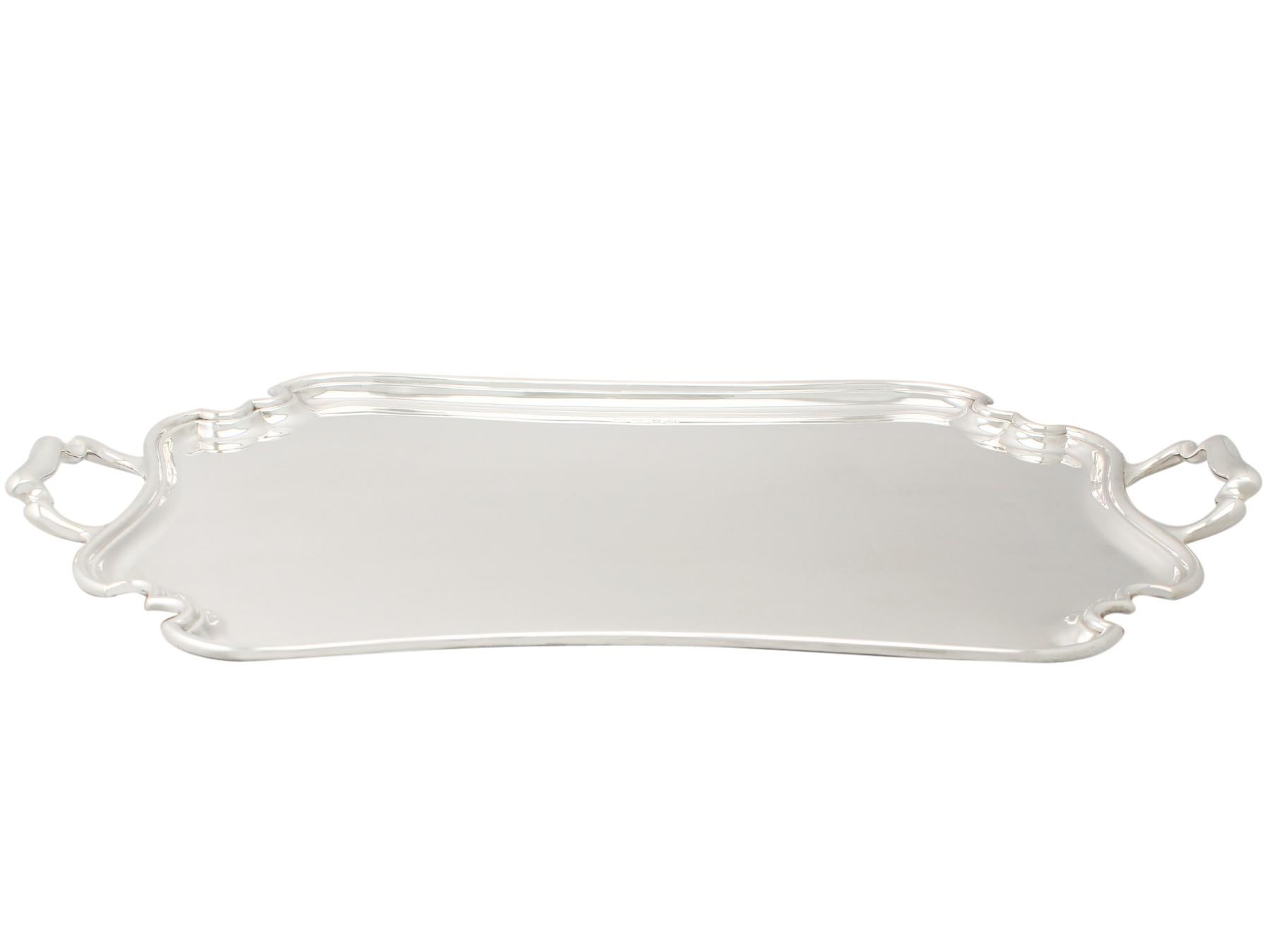 An exceptional, fine and impressive antique George V English sterling silver two-handled tea tray; part of our silverware collection.

This exceptional antique George V sterling silver tray has a rectangular shaped form with incurved
