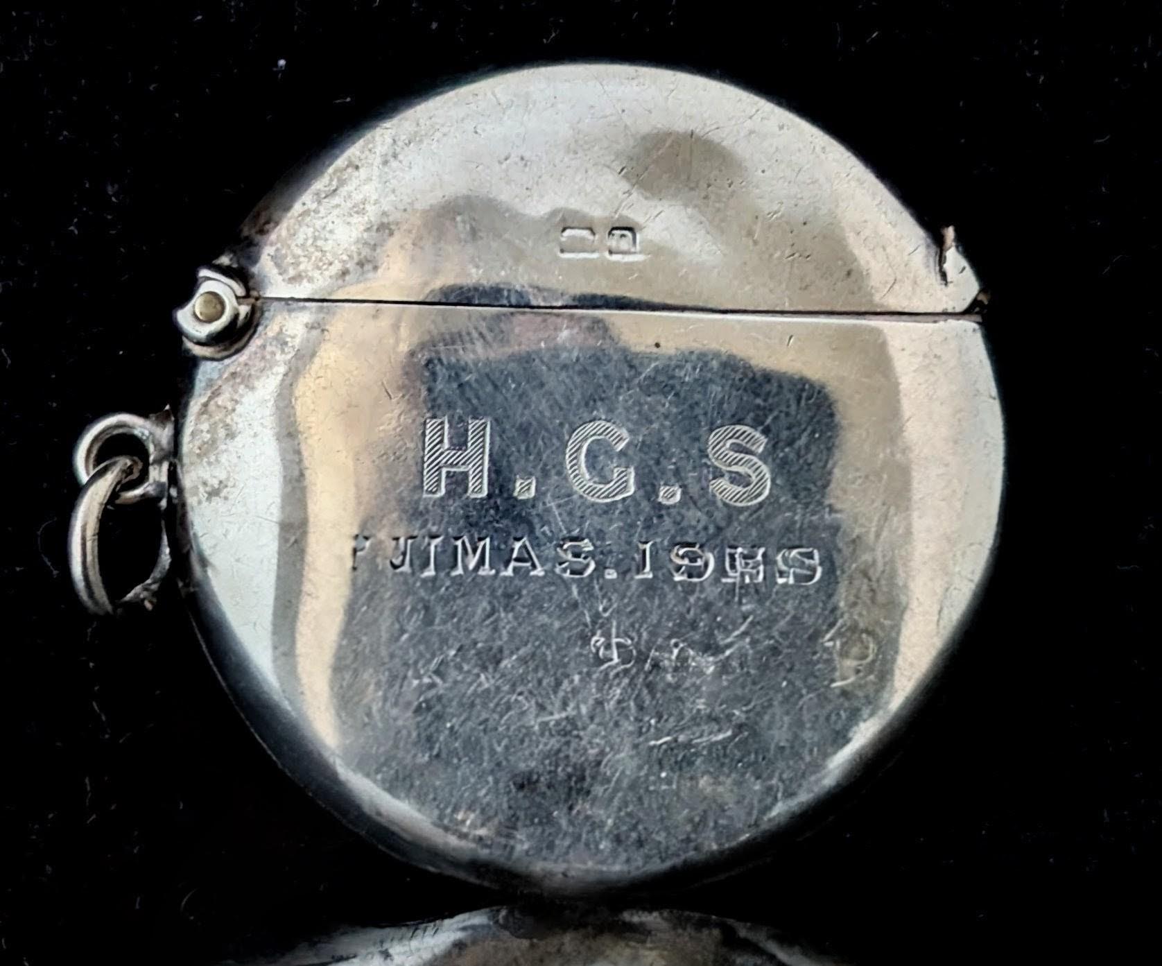 A fantastic little antique sterling silver vesta case.

Made in England it is a circular shaped Vesta case designed to be added to an antique silver Albert chain and filled with matches for lighting on the go.

It has an integral striker to the