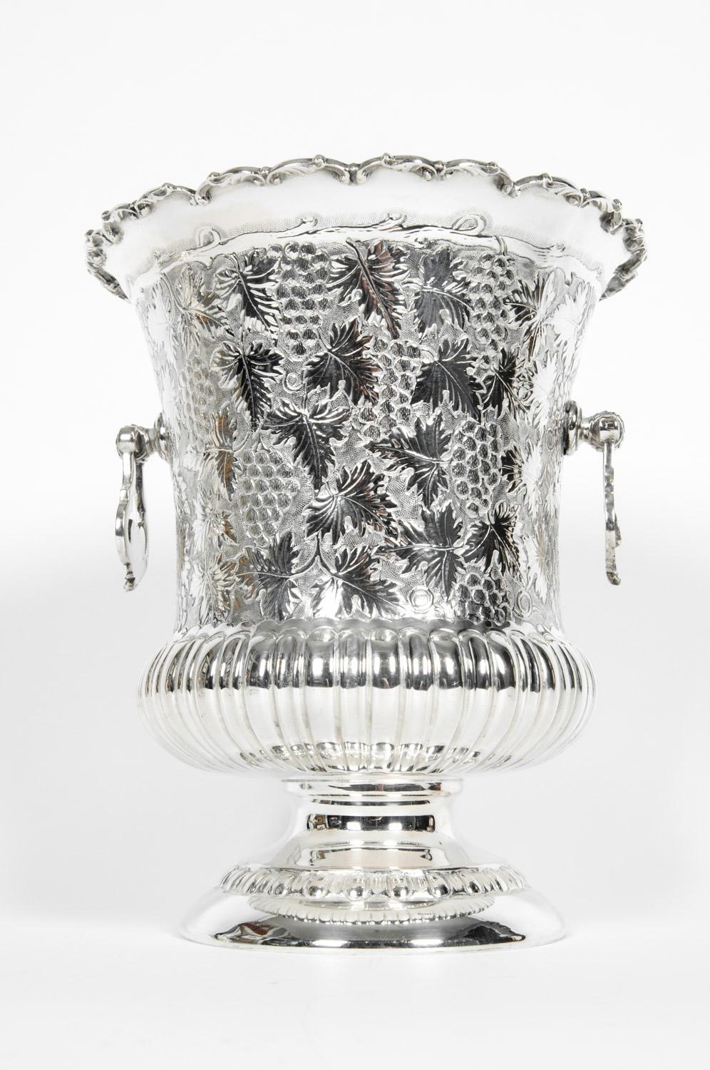 Antique sterling silver barware or wine cooler with two sides handle with grapes design details. The piece is in excellent condition. Maker's mark undersigned. The sterling cooler measure about 10 inches high x 9 inches diameter. Base diameter 6