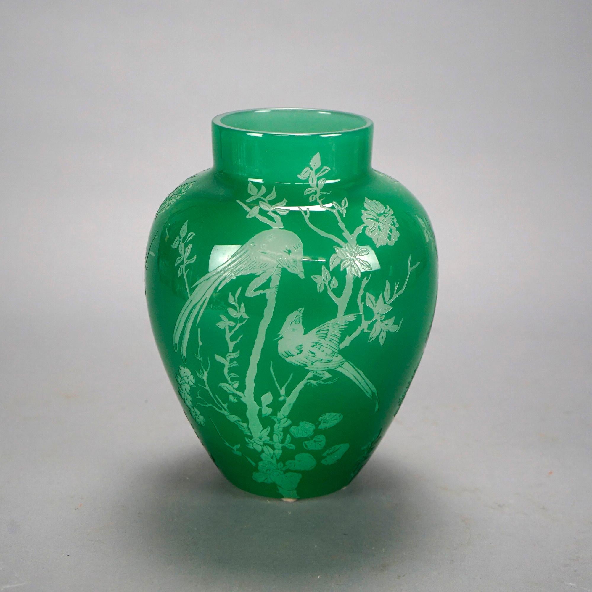 An antique vase by Steuben offers jade art glass construction with cutback garden scene having Asian birds and flowers, unsigned, c1930.

Measures- 9.25''H x 7''W x 7''D.