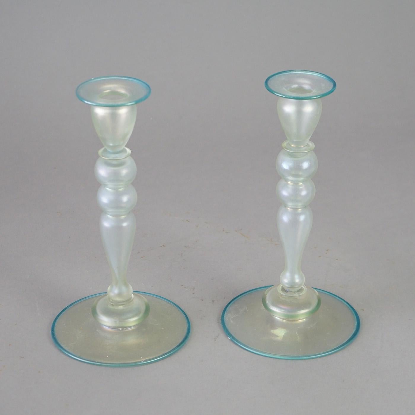 An antique pair of candle sticks by Steuben offer Verre De Soie art glass construction in balustrade form with blue rimming, c1920

Measures - 10