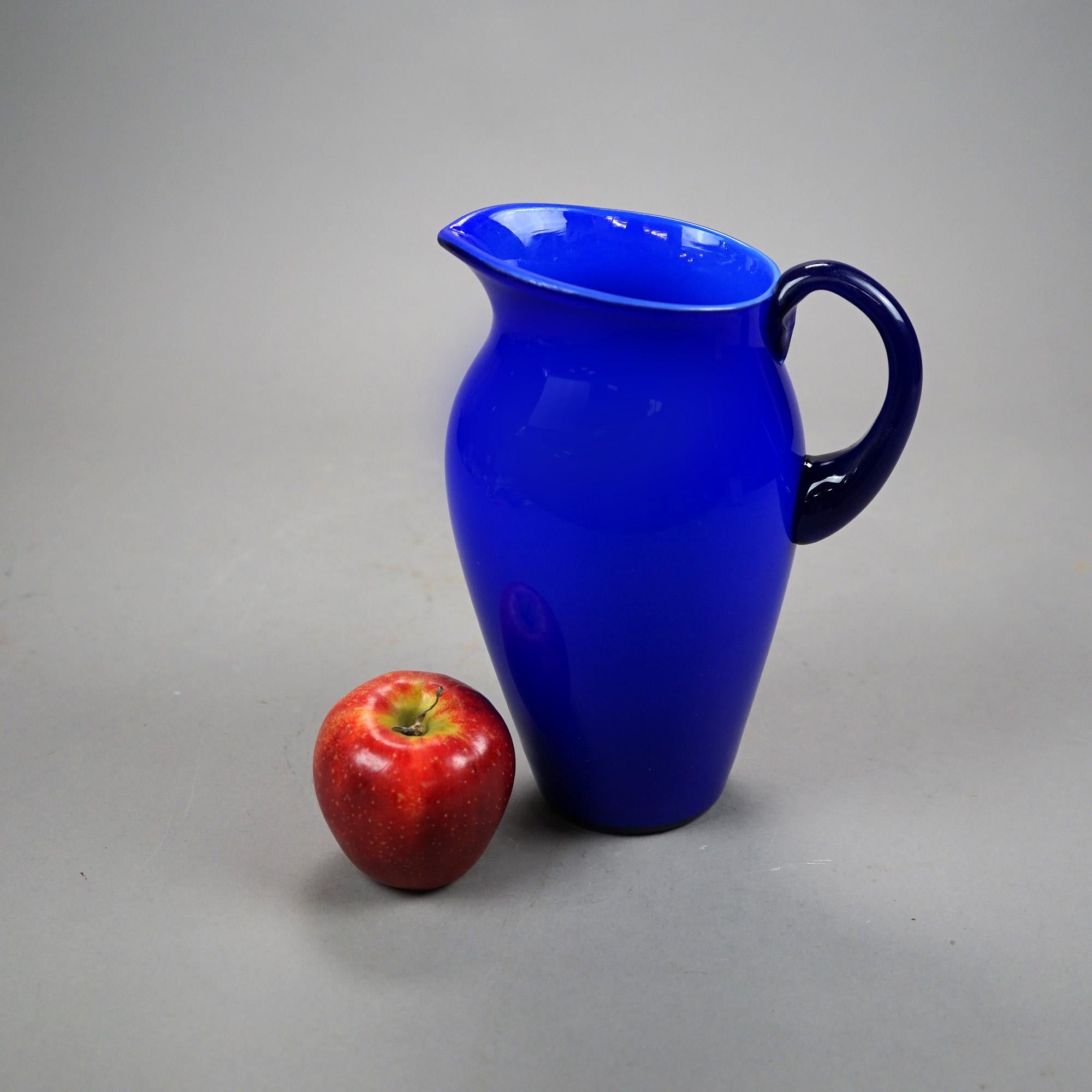 An antique water pitcher by Steuben offers blue jade art glass construction, unsigned, c1920

Measures- 9.5''H x 7''W x 5.5''D.

Catalogue Note: Ask about DISCOUNTED DELIVERY RATES available to most regions within 1,500 miles of New York.