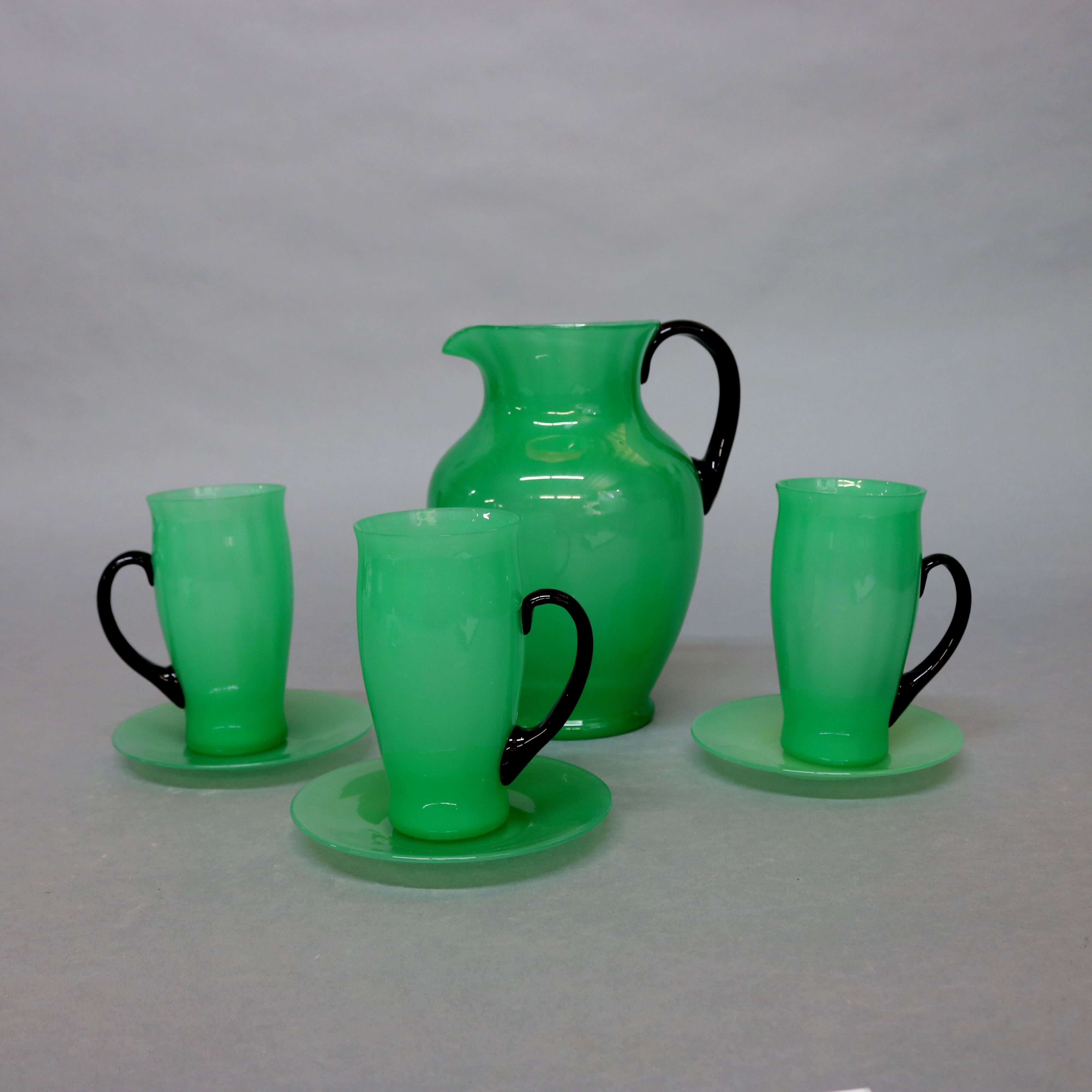 Antique handcrafted Steuben chocolate set features jade green art glass with black handles and includes a pitcher with three handled cups and saucers, circa 1930.

Measures: pitcher 9.5