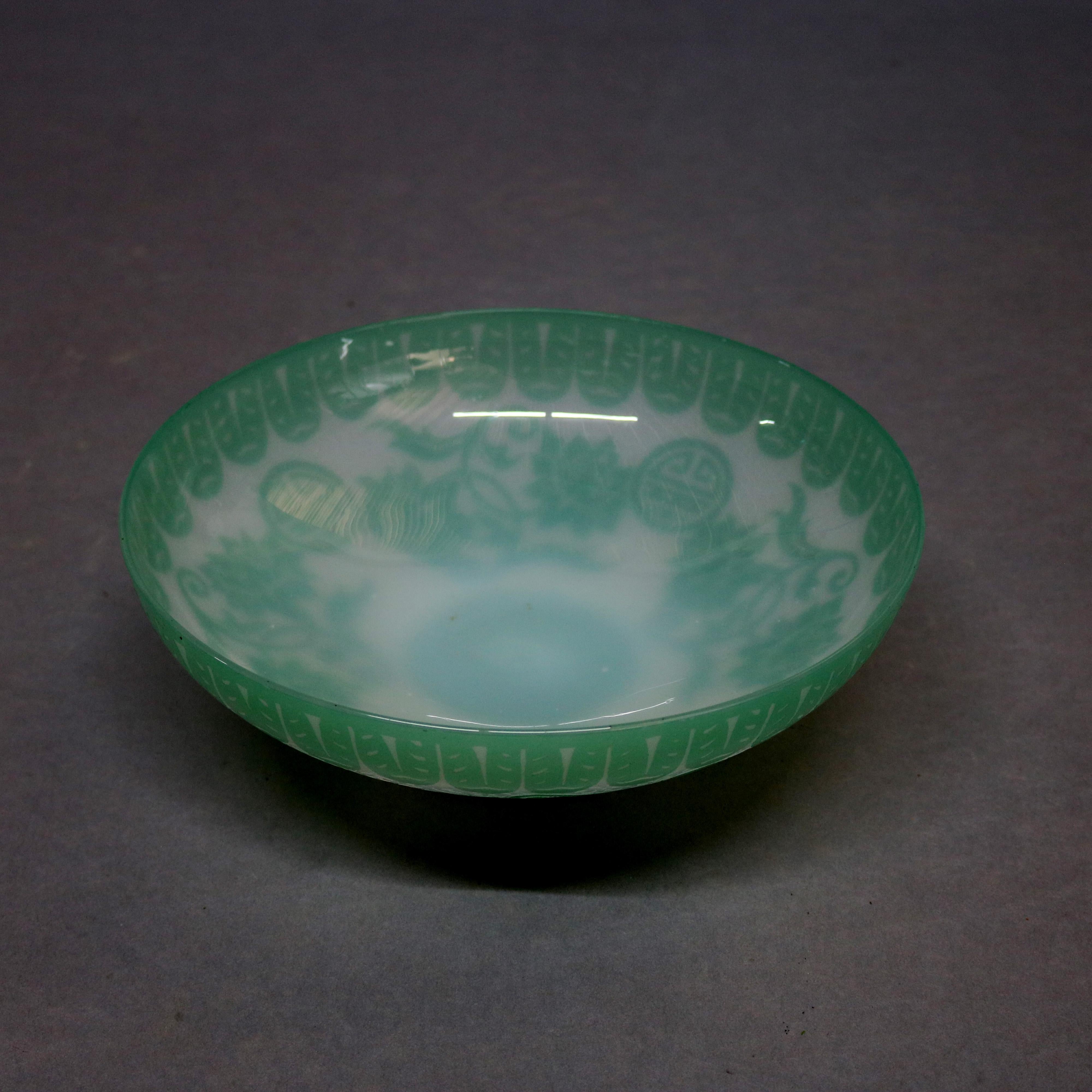 An antique early Steuben Corning Museum of Glass handcrafted jade green art glass center bowl (Shape 2852) with chinoiserie acid-cutback Chinese pattern of floral peonies and Chinese symbol for Good Luck, unsigned and guaranteed authentic, circa