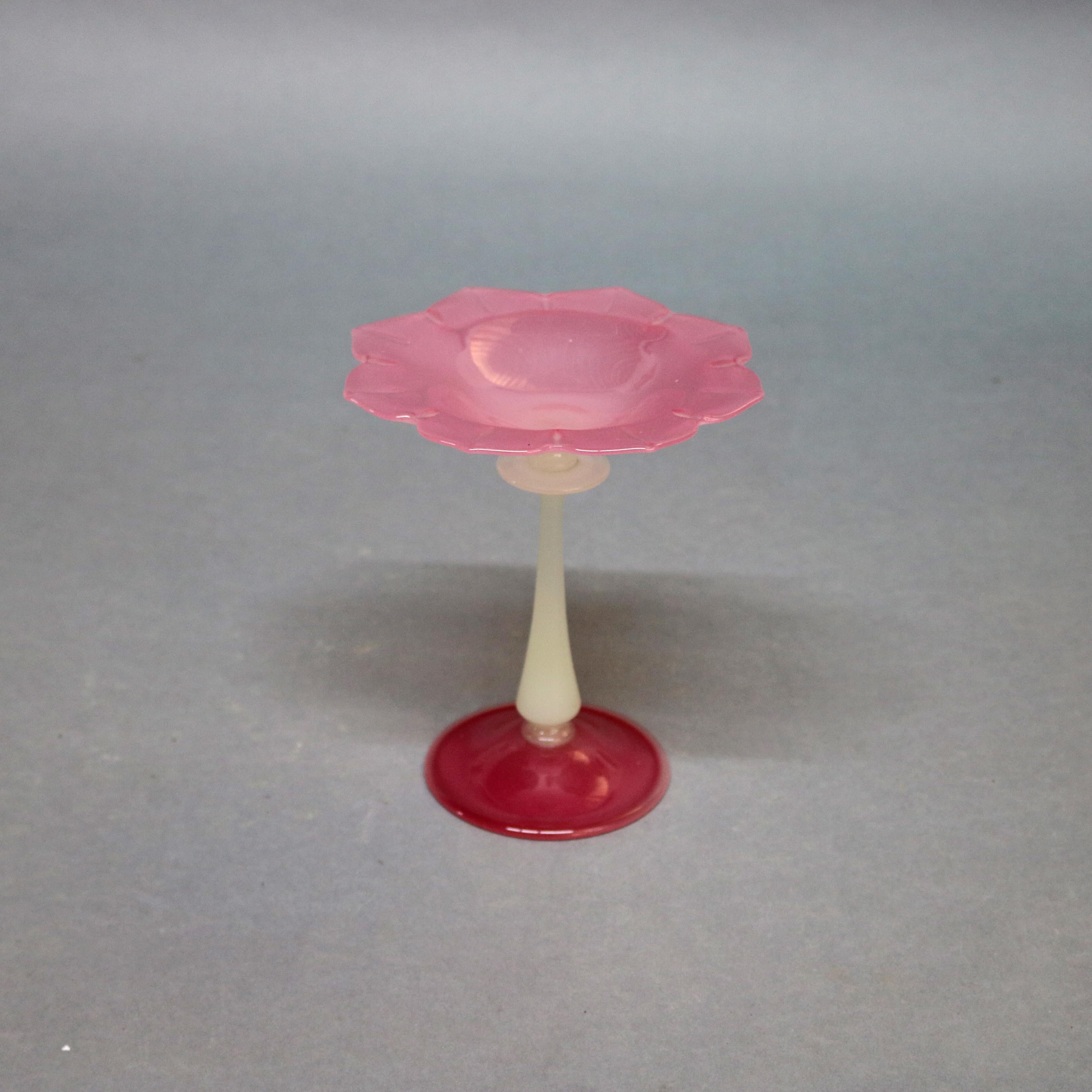 Steuben art glass compote features Rosaline floral form bowl surmounting alabaster stem seated on Rosaline foot
art glass Rosaline opalescent compote, circa 1930.

Measures: 8.25
