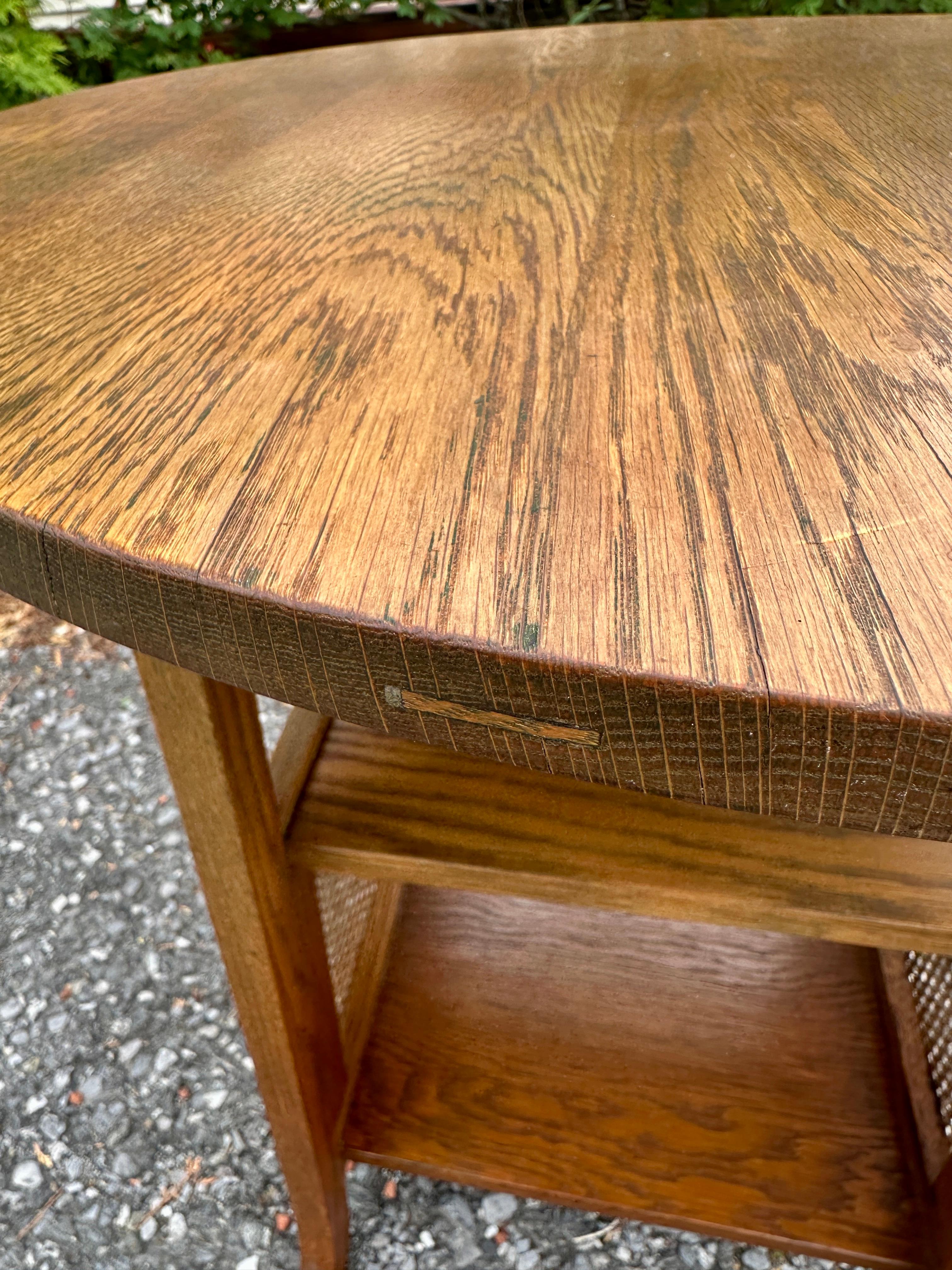 This is an antique Stickley Brothers Lamp Table.  It was made in 1910. The table is in perfect condition, including the wicker. There are two lower shelves, one is 12.75