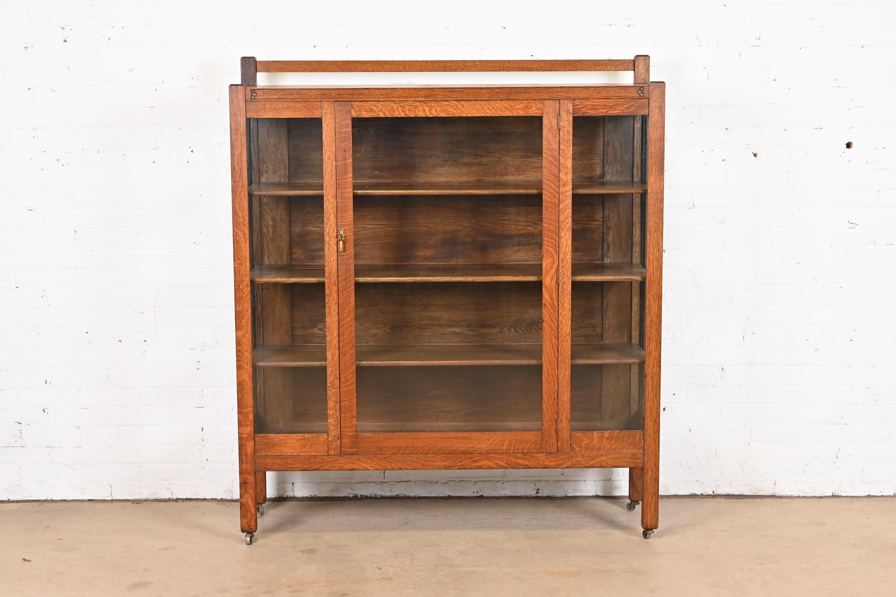 A gorgeous antique Mission or Arts & Crafts bookcase or display cabinet

In the manner of Stickley Brothers

USA, Circa 1900

Carved quarter sawn oak, with glass front doors and sides, and original brass hardware. Cabinet locks, and key is