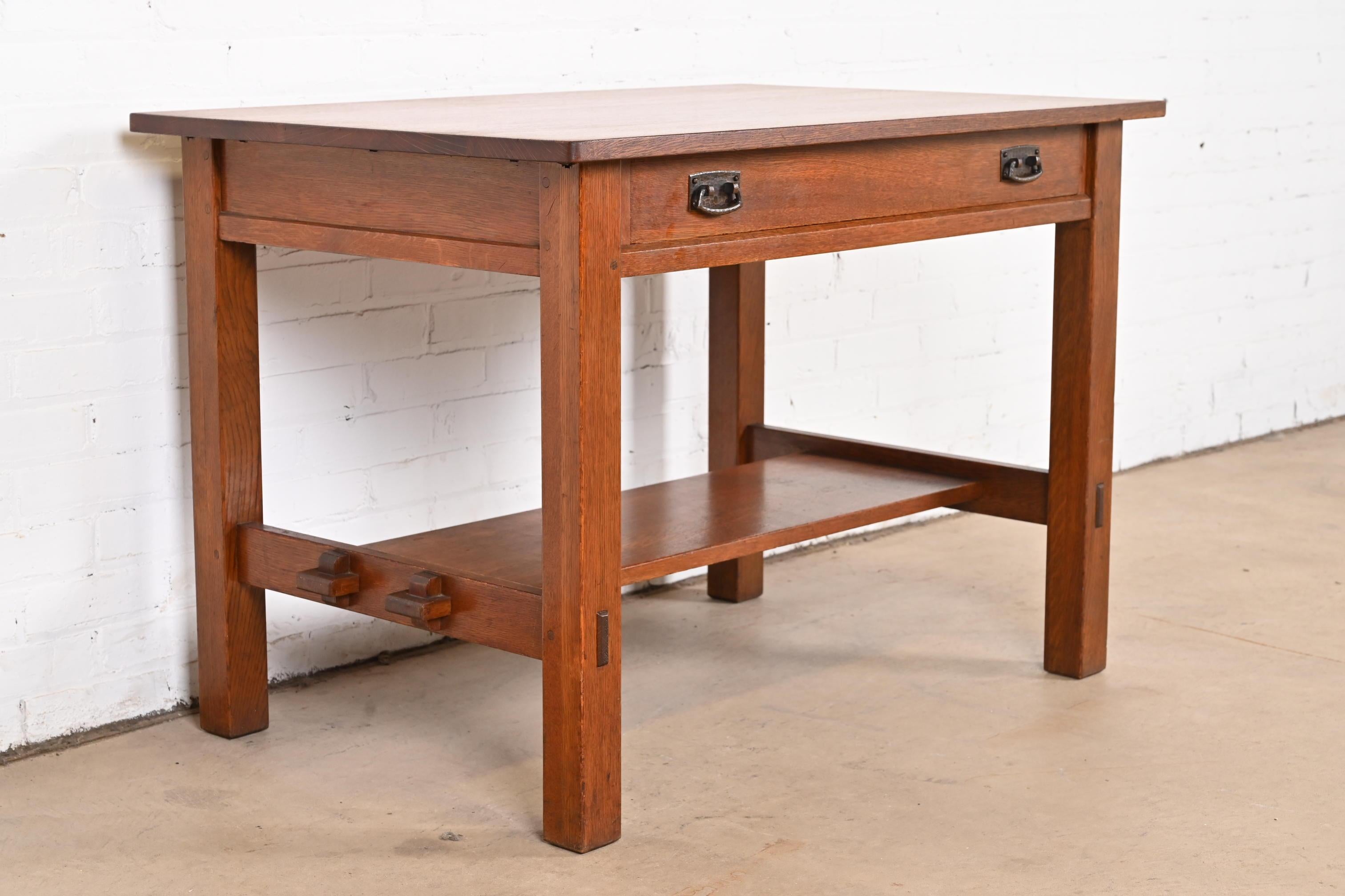 An exceptional antique Mission or Arts & Crafts writing desk or library table

By L. & J.G. Stickley

USA, Circa 1900

Solid quarter sawn oak, with original hammered copper hardware.

Measures: 42