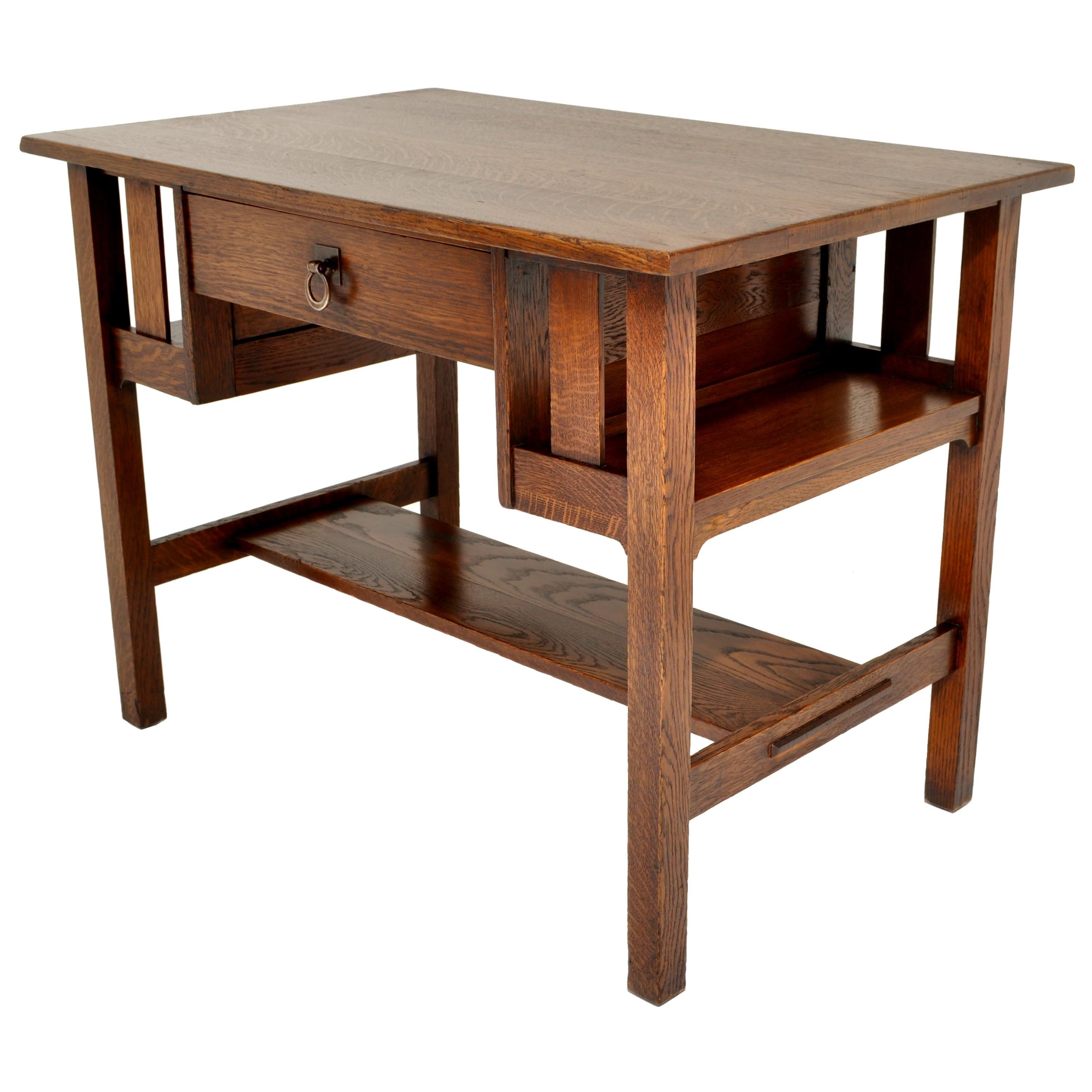 A good, antique, Stickley Bros Mission/ Arts & Crafts oak writing/ library table, circa 1905. The table having a overhanging top above twin bookcases to each side and a central drawer with the original hand forged bronze handle, the table having a