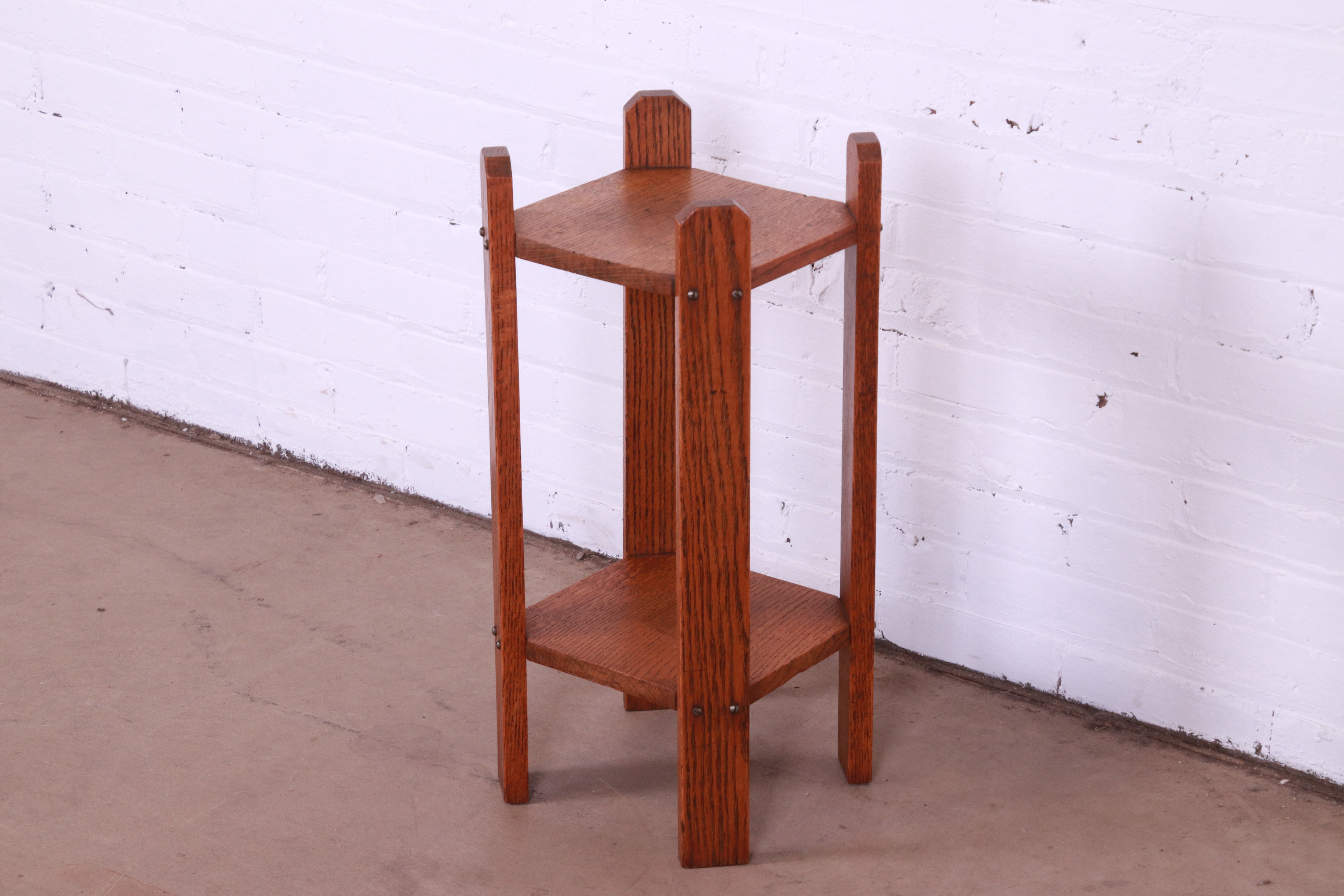 A beautiful antique Mission or Arts & Crafts solid quarter sawn oak two-tier occasional side table.

Recently procured from Frank Lloyd Wright's DeRhodes House.

In the manner of Stickley.

USA, Circa 1900.

Measures: 11.25