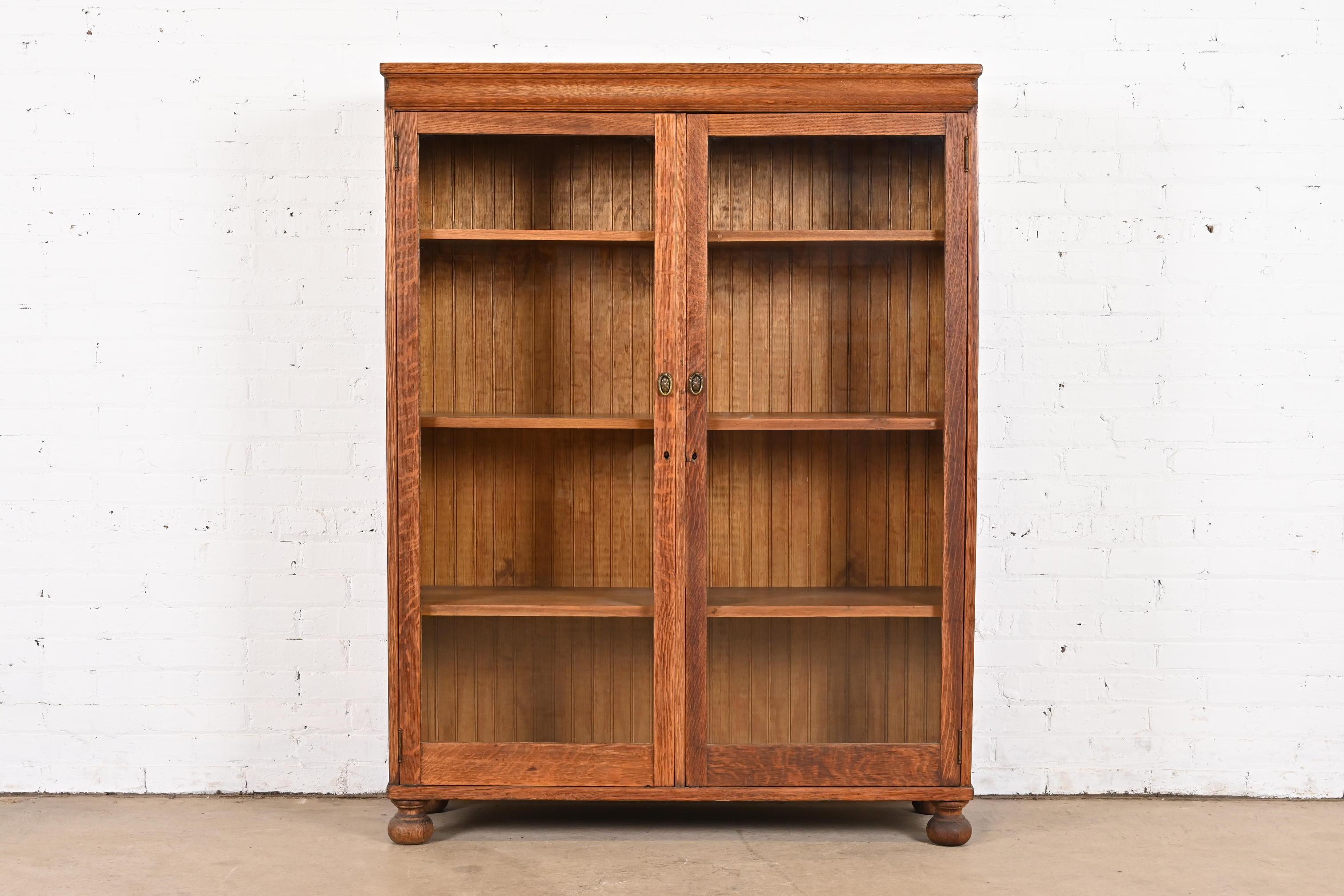 A beautiful antique Arts & Crafts double bookcase cabinet

In the manner of Stickley Brothers

USA, Circa 1900

Carved oak, with glass front doors and brass hardware.

Measures: 44.25