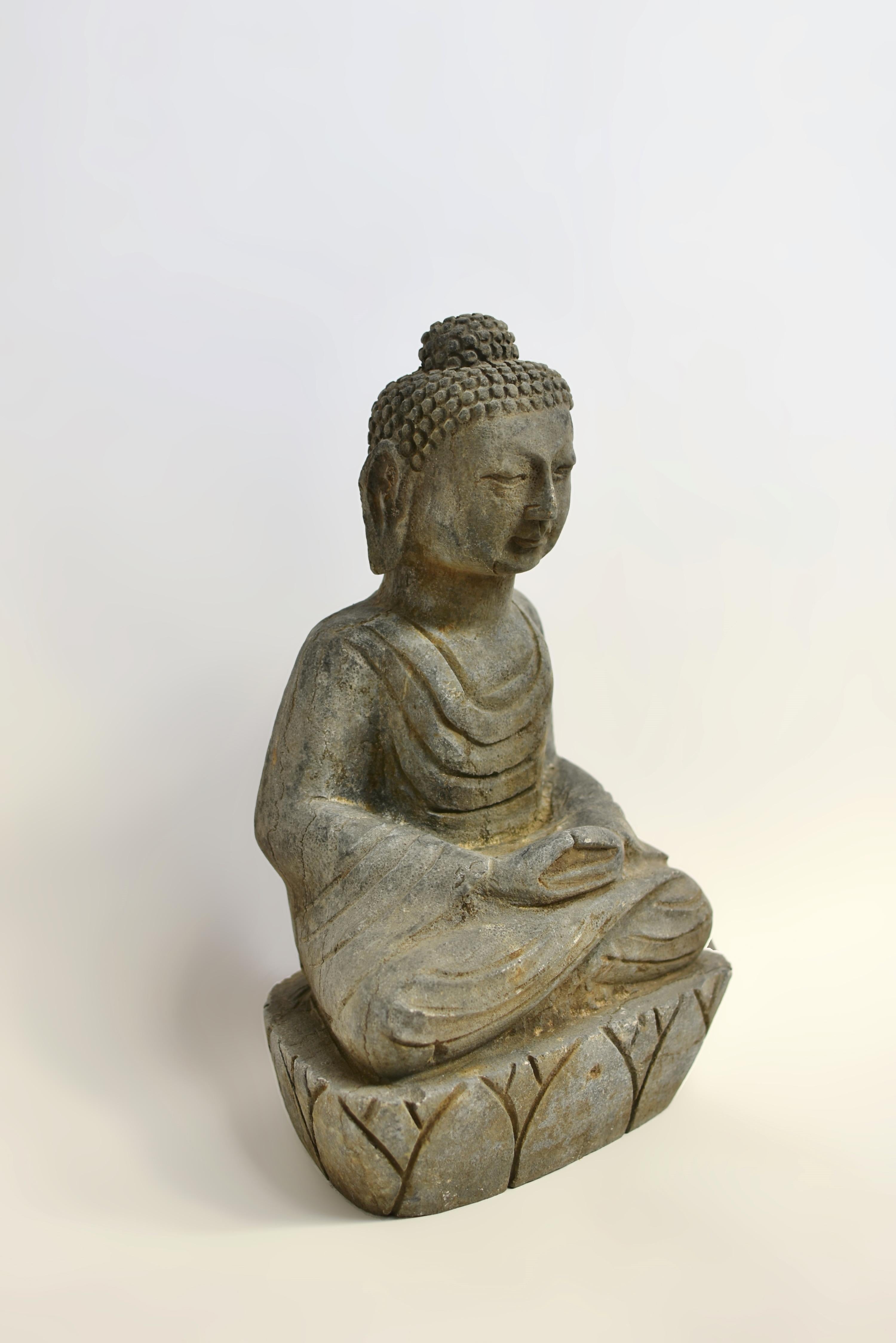 A beautiful 29-lb hand-carved solid stone Buddha. Seated dhyana asana upon a lotus base, with hands in the dhyana mudra. Buddha gazes serenely downward, his full face in the Tang style with long earlobes and neatly coiled chignon. A fluid robe