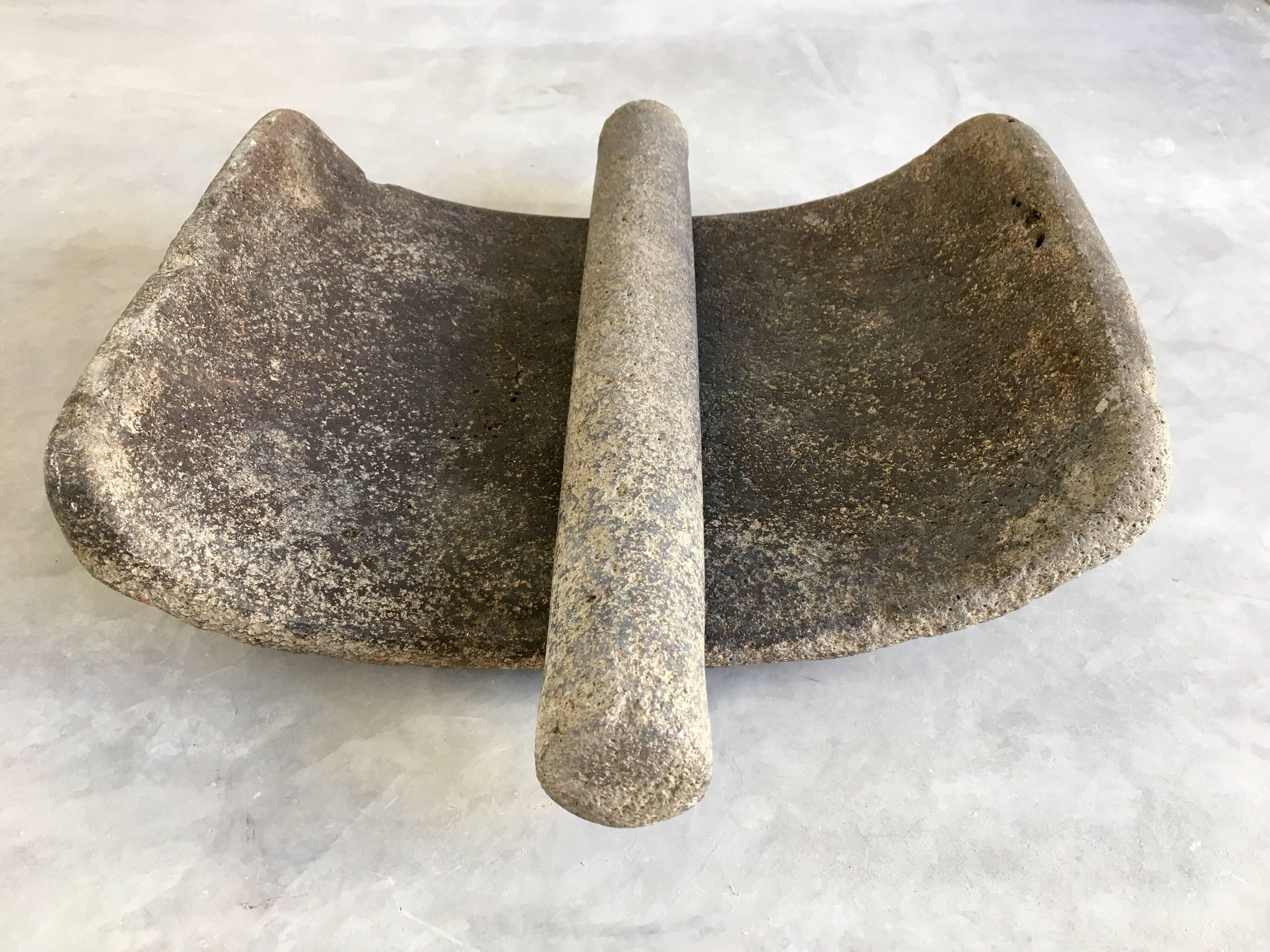 Primitive-styled, indigenous mortar from the Otomi people of the Hidalgo/Guanajuato border area, Mexico. Used to grind corn as well as other coarse grains. Original grinding arm is included. Made of volcanic stone of a very dense nature given it's