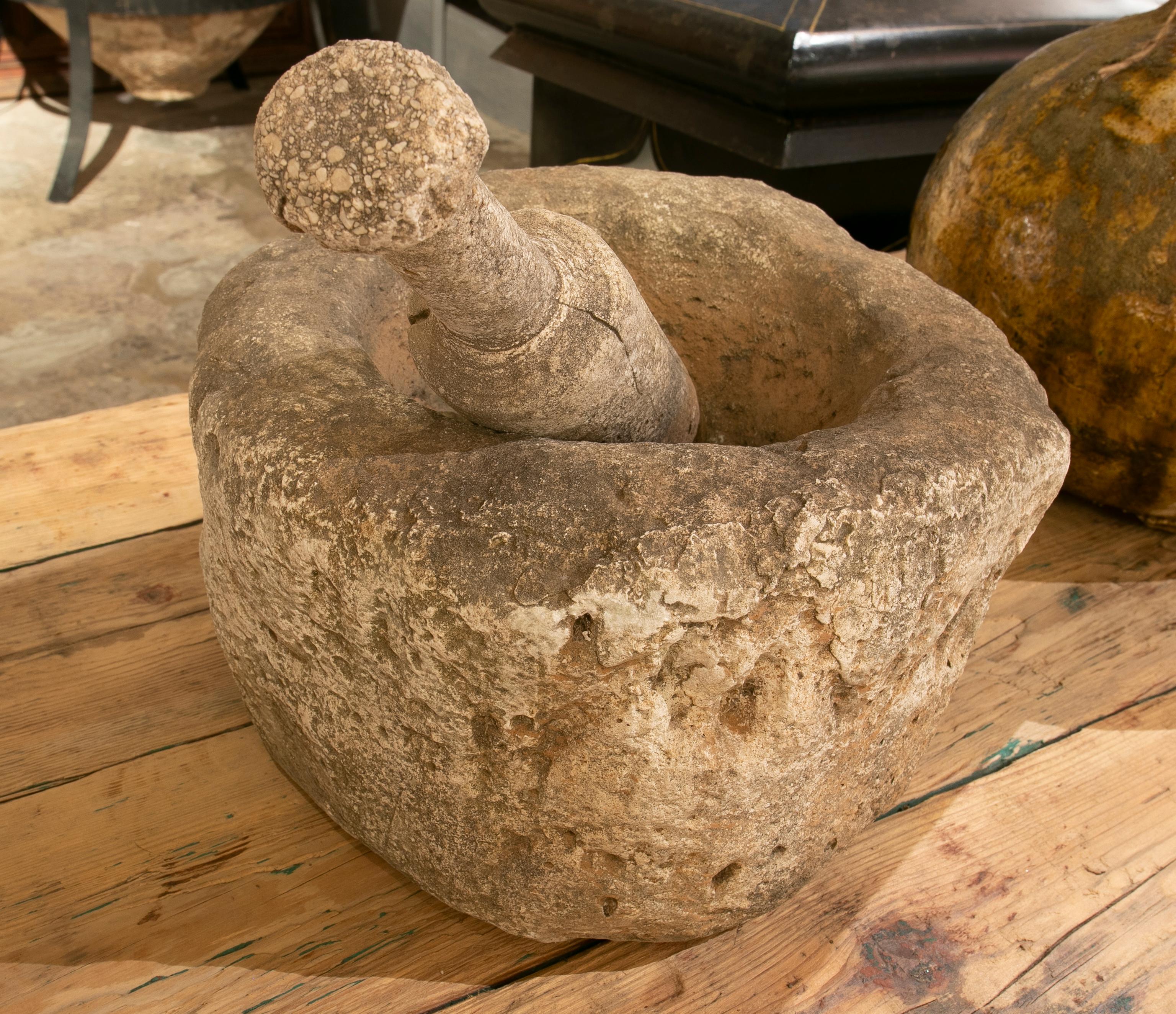 Antique stone mortar with mallet. This last piece has a measure of 34 centimetres.
 