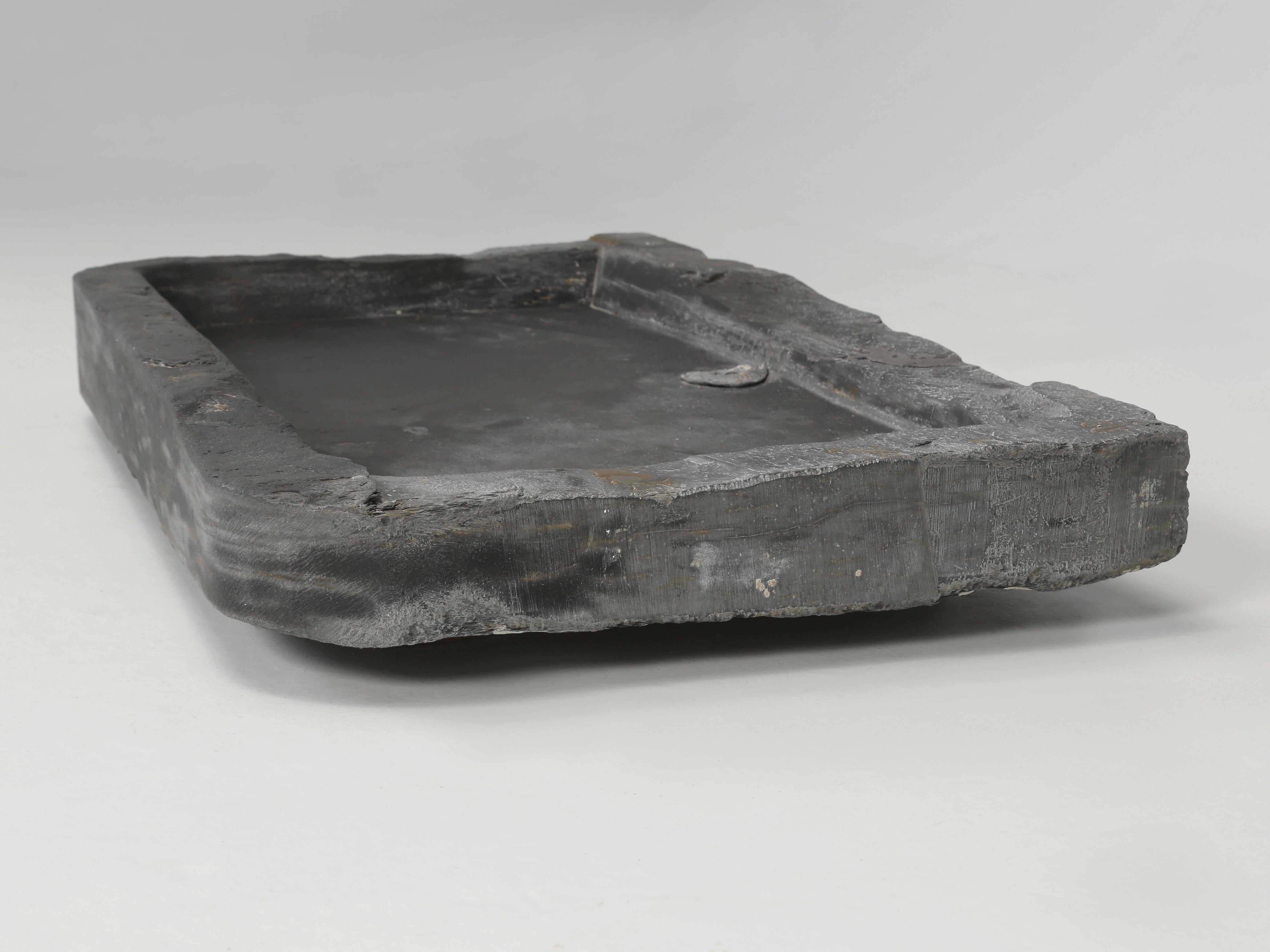 Antique stone sink made from Belgium bluestone is our best guess and probably from the mid-1800's. There is an old drain that is not in the best of condition and clearly requires replacement. We don't see any prior repairs to the sink itself and we