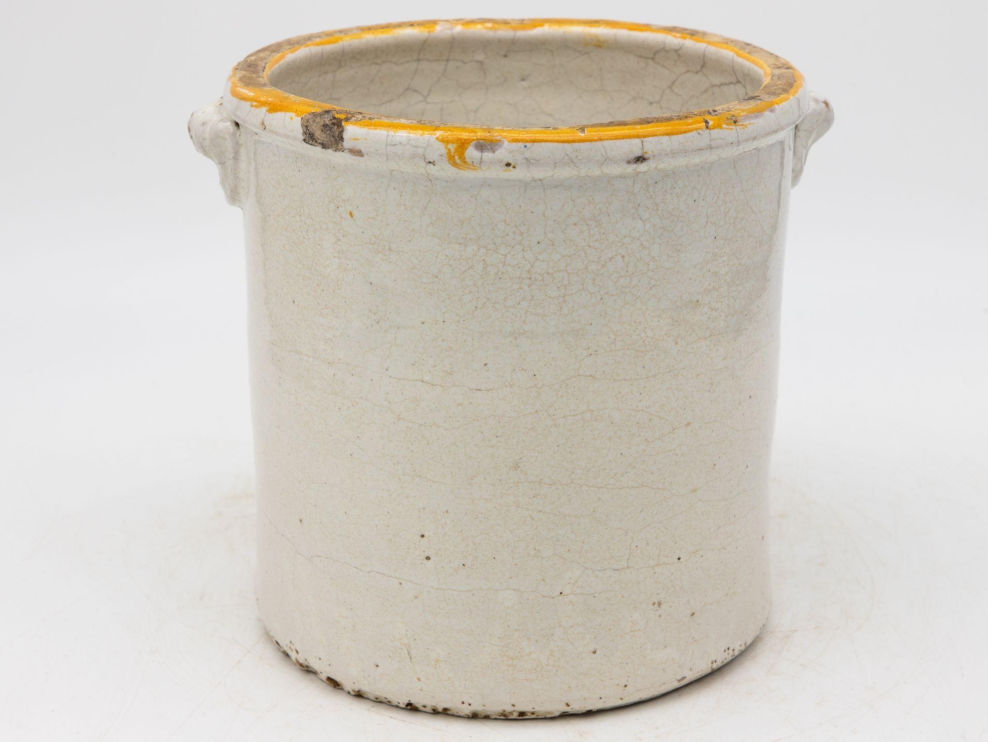 Questa affascinante pentola per confetture in gres francese del XIX secolo presenta un morbido smalto color crema e una forma classica e arrotondata. Le sottili imperfezioni e le schegge consumate dal tempo ne esaltano il carattere autentico,