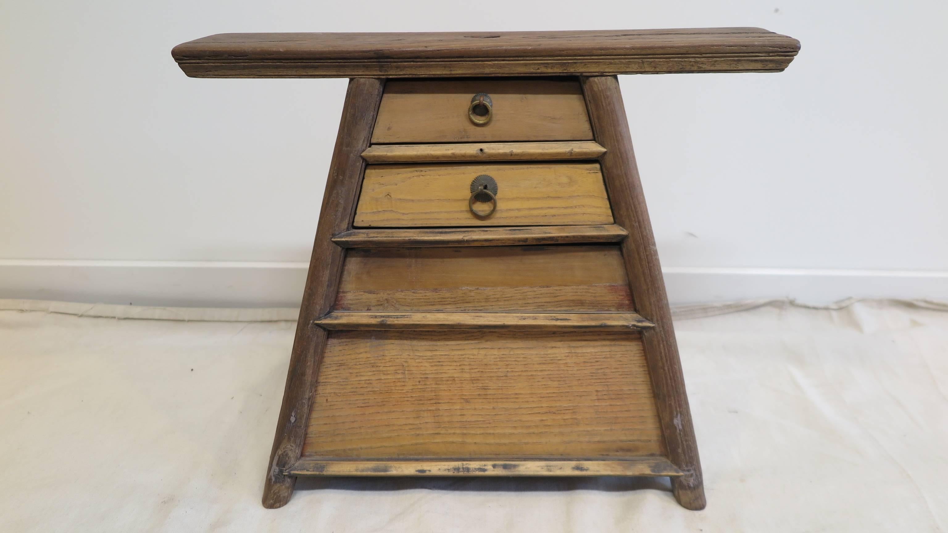 19th century Chinese Stool. This is an antique Barber stool.  Natural wood stool of Elm wood.  The stool has two small drawers in the front, and a larger drawer on the side to the bottom. The seat has a hole in the middle of the top which is where