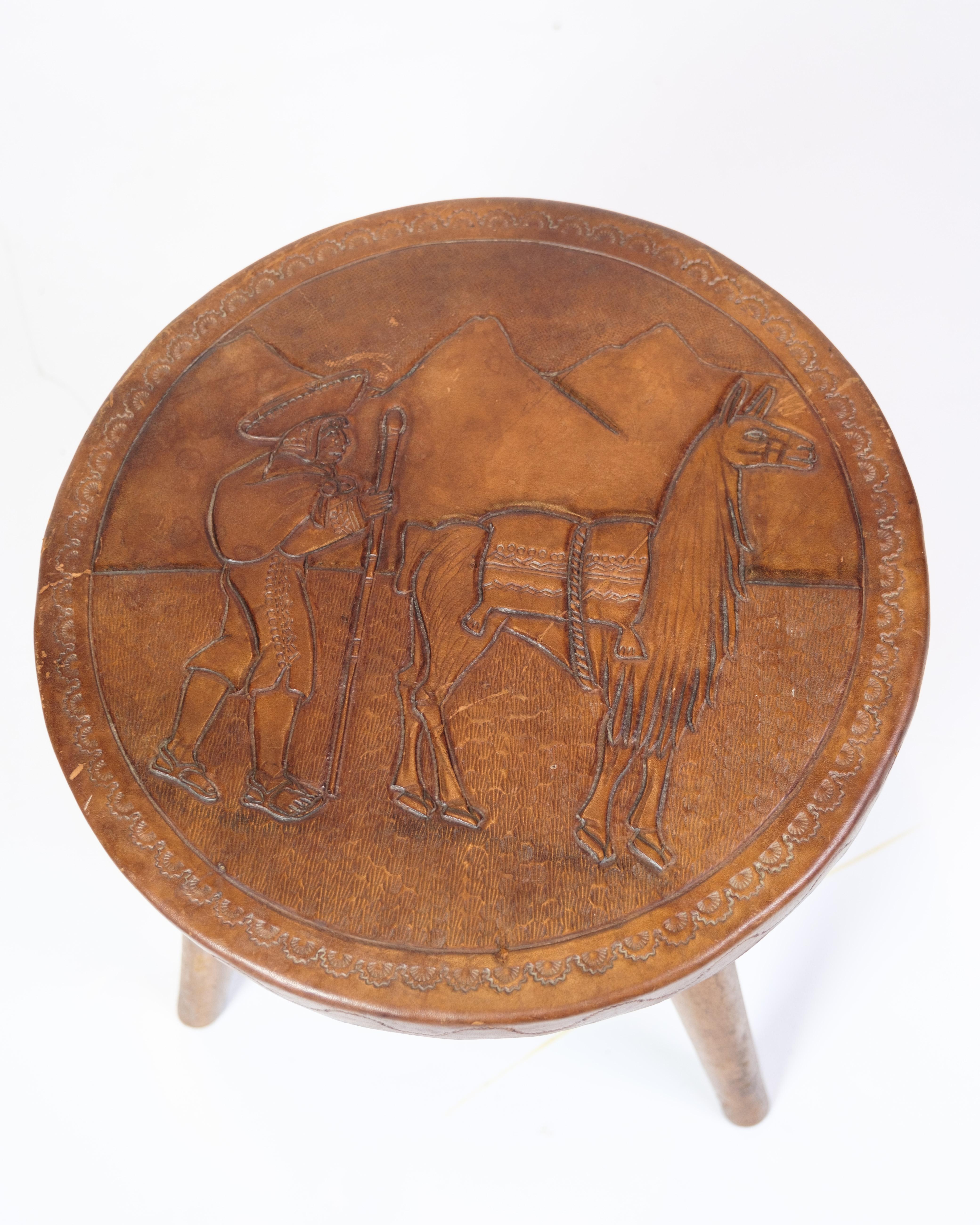 This antique stool is a specimen of fine craftsmanship, bearing a motif of a farmer with an alpaca, carved with care and precision. The motif not only shows a beautiful staging of peasant life, but also a tribute to the beauty of nature and rural