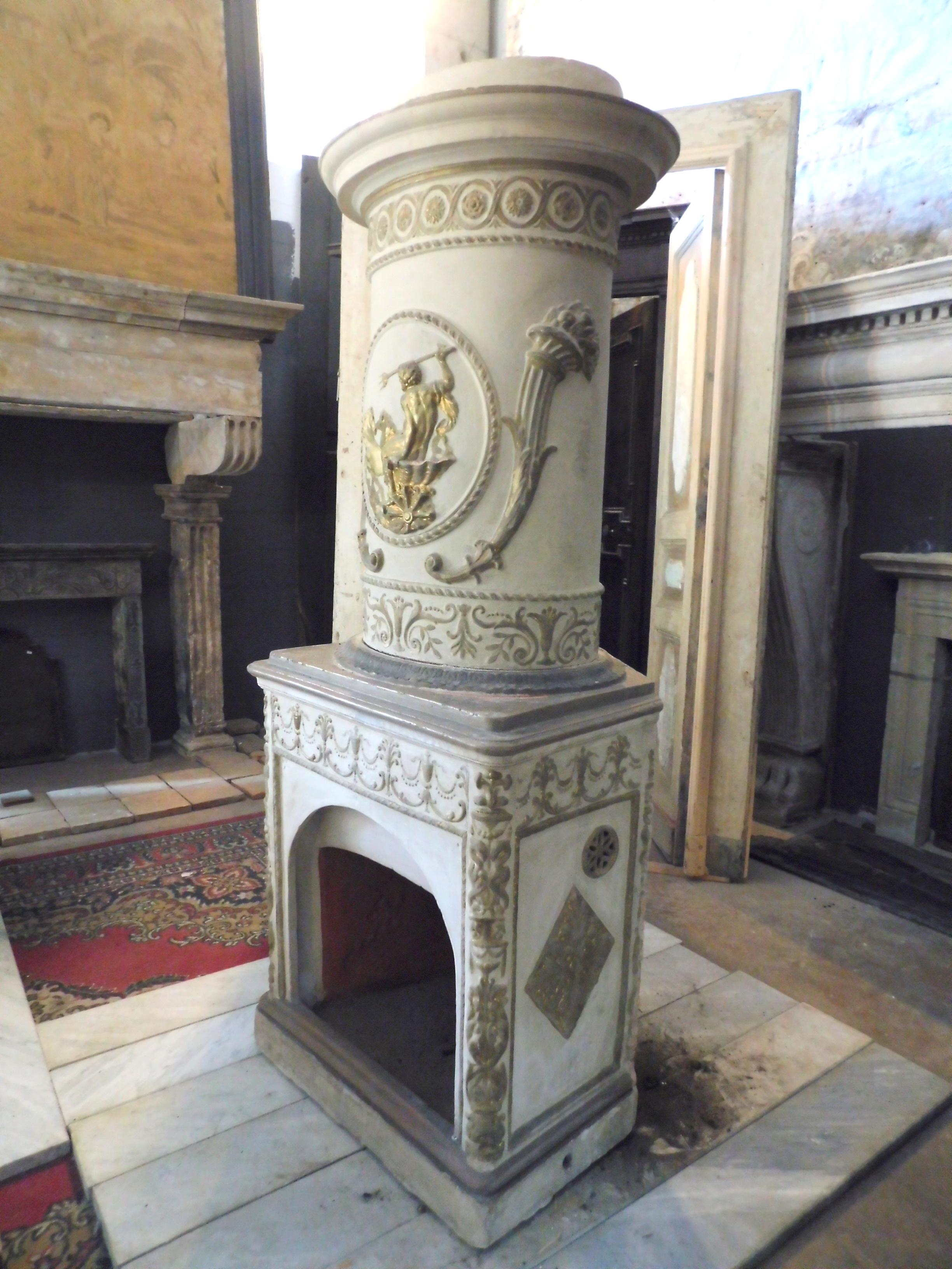 Antique ceramic stove, Italian-made ceramic white painted and gold decorations, on a red earth base as seen from the inside, covered with beautiful decoration of the time, hand carved that create an interesting texture, a typical Italian product
