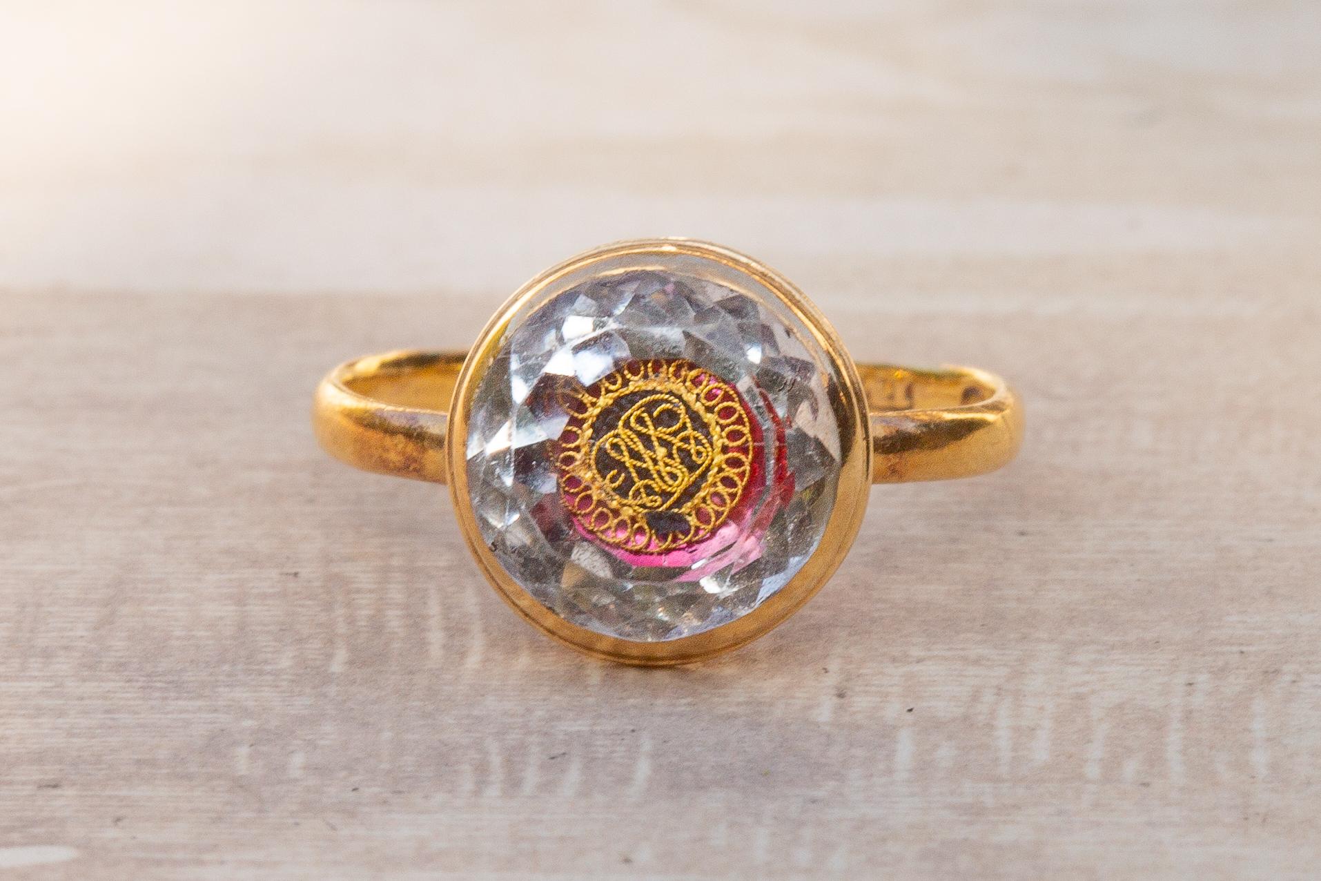 An exquisite early 18th century Stuart rock crystal ring. Inlaid with a knotted gold wire cypher and flashes of berry-pink foil underneath, this ring is steeped with English history and is a remarkable example of Stuart period jewellery. 

The group