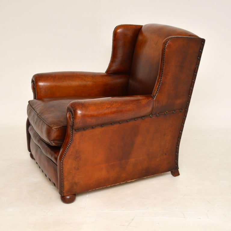 A wonderful and extremely comfortable antique studded leather club armchair. This was made in England & it dates from around the 1900 period.

The quality is superb and this has very generous proportions. It is deep and comfortable, with a feather