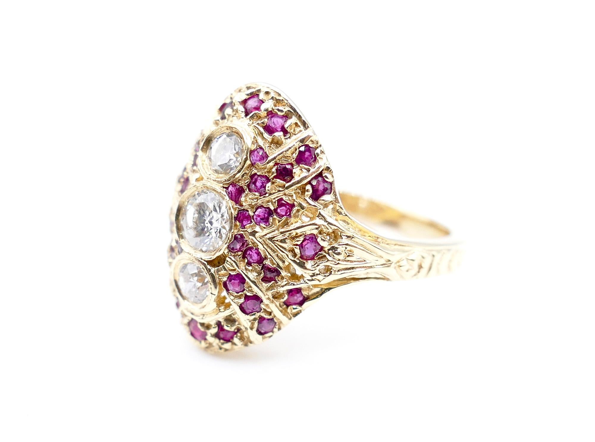 This gorgeous, Antique-Style Dinner custom ring includes 3 shiny white, round-cut, bezel-set Diamonds that line up at the center, weighing in at 0.5 Carats total. The diamonds are surrounded by numerous small rubies. The rubies, weigh in at 1 Carat