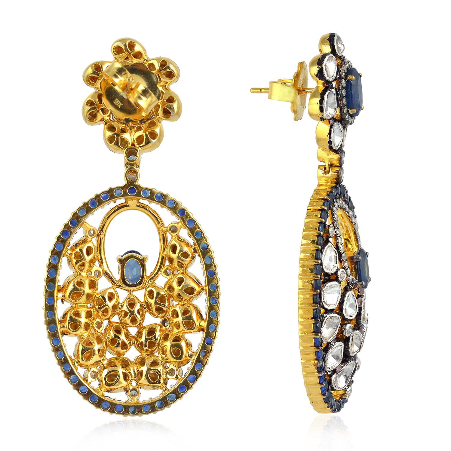 Inspirées de l'ère moghole et de l'héritage royal, ces superbes boucles d'oreilles sont fabriquées à la main en or 18 carats et en argent sterling.  Elles présentent une silhouette de style lustre incrustée de saphir bleu de 7,87 carats et de