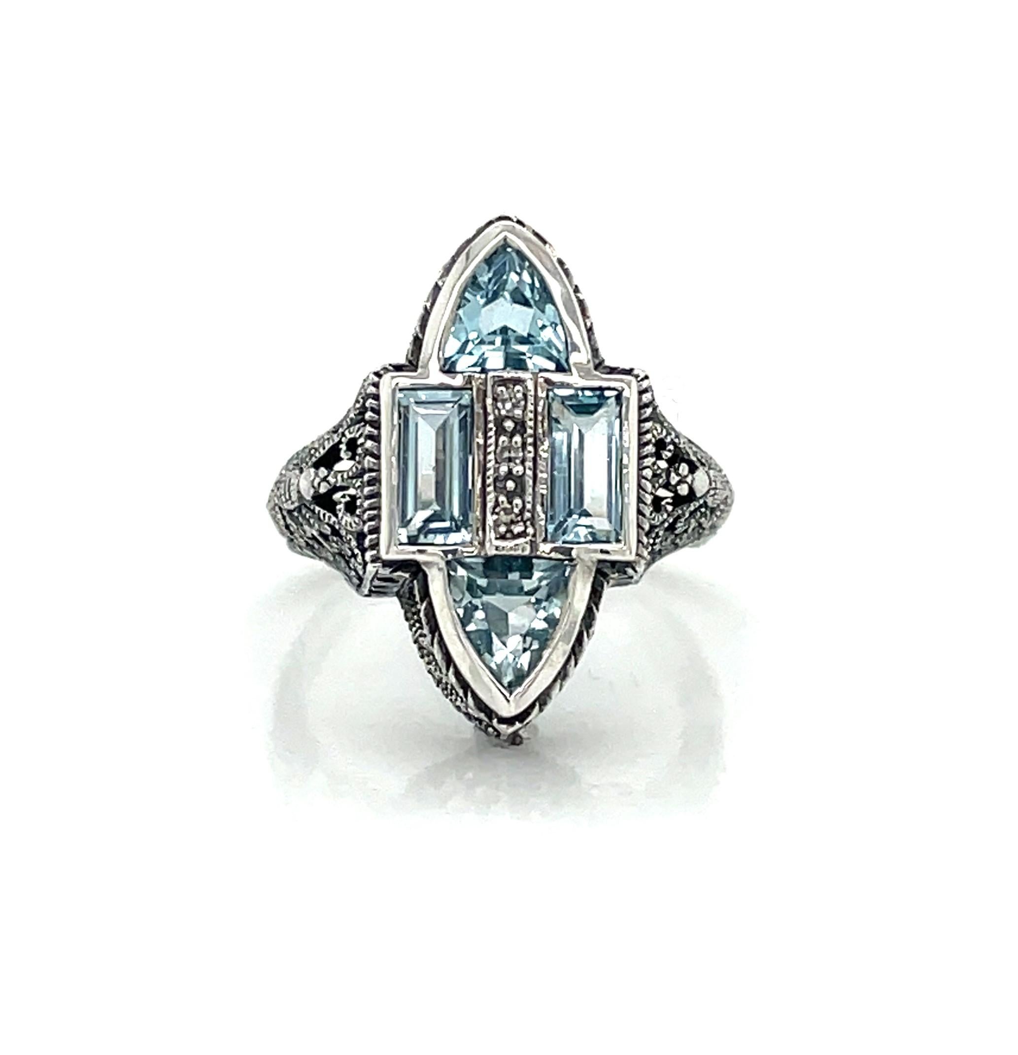 Four stunning mixed cut blue topaz stones accented with diamonds are displayed in this antique-style .925 sterling silver filigree ring. 
In ring size 6. New and presented in miniature antique style ring gift box.     