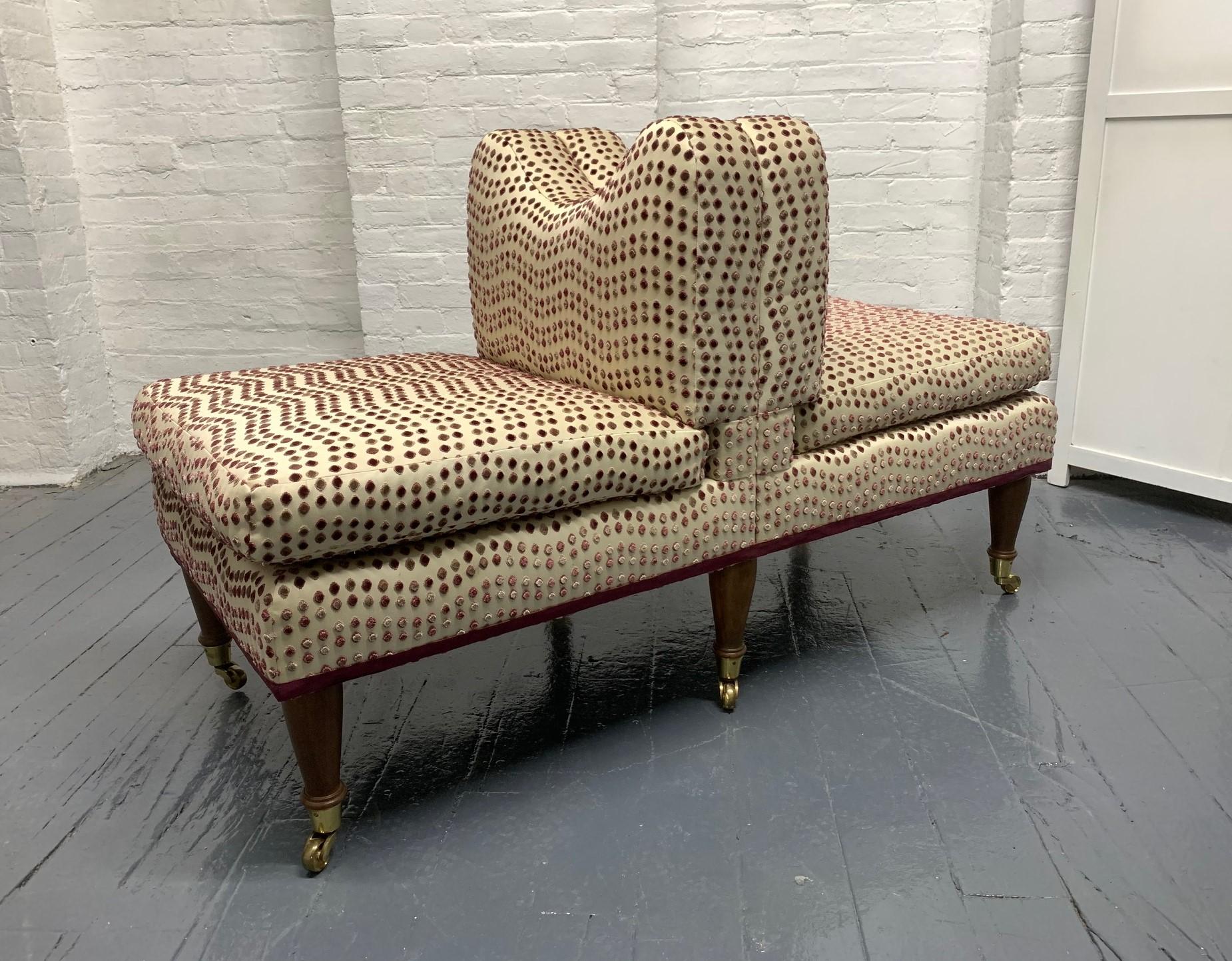 Antique style custom made Tete-a-Tete having mahogany legs with brass casters and the original upholstery. 
The Tete-a-Tete has a heart shaped center back with loose cushioned seats.