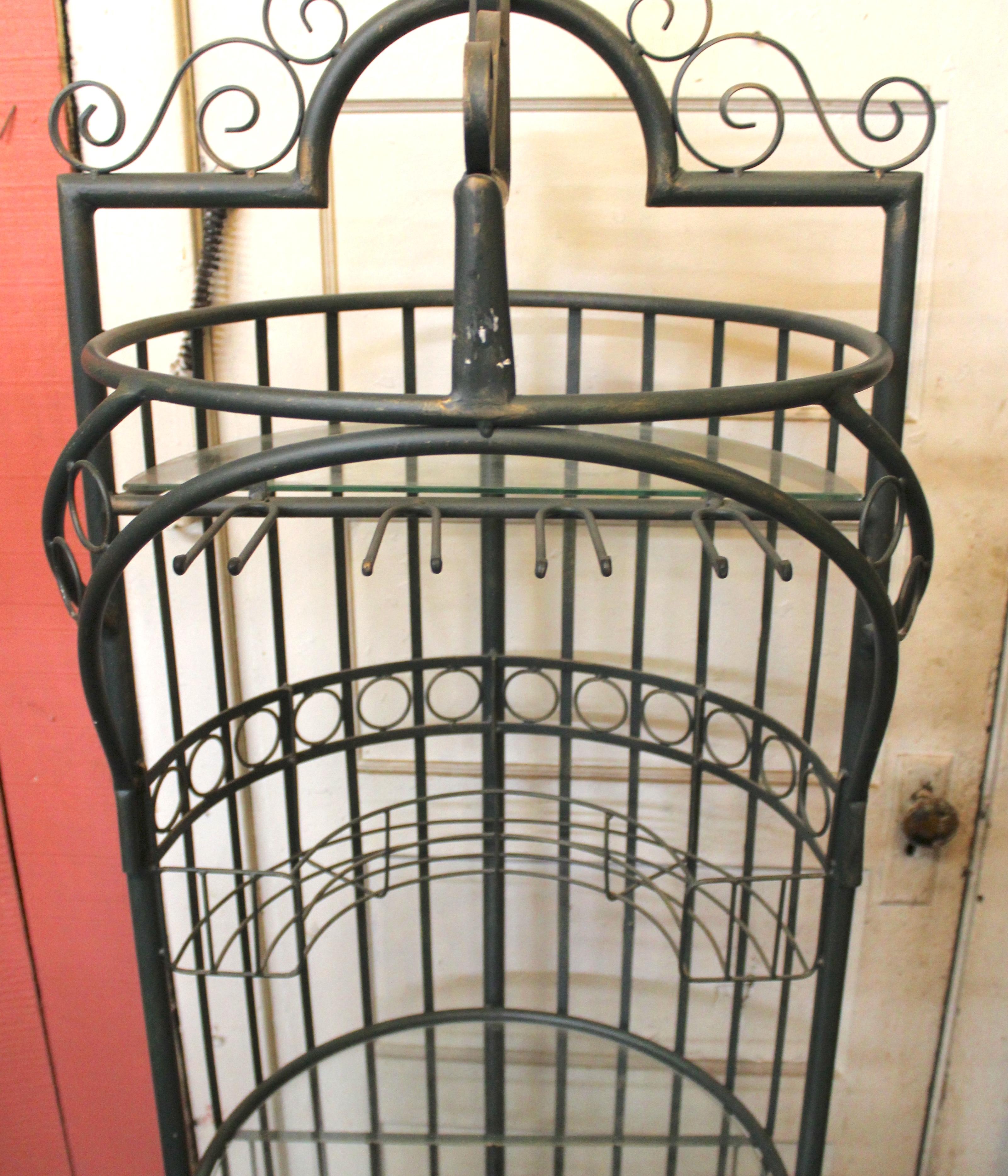 Unité de stockage de six pieds de haut pour le vin et les verres. Forme ronde unique avec des volutes en fer ornées et deux étagères en verre. 
Veuillez confirmer le lieu avec le vendeur NY ou NJ