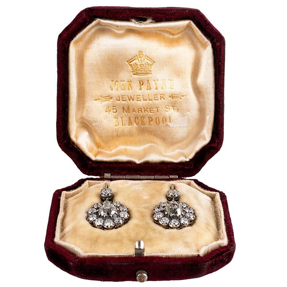 A modern rendering of a classic antique style, with old European brilliant white diamonds assembled in a classic cluster design that resembles a flower shape with scalloped edges. The diamonds weigh 3.51 carats in total. Made of silver over 18 karat