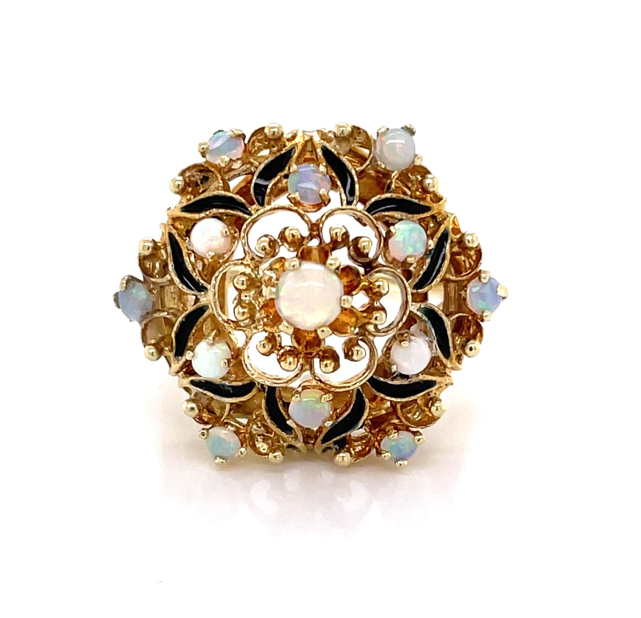 A ribbon of hand painted black enamel outlines the floral inspiration of this artful fourteen karat 14K yellow gold vintage cocktail ring. With an antique style setting, elegant gold filigree sits high a top the ring's ornate gallery and hosts