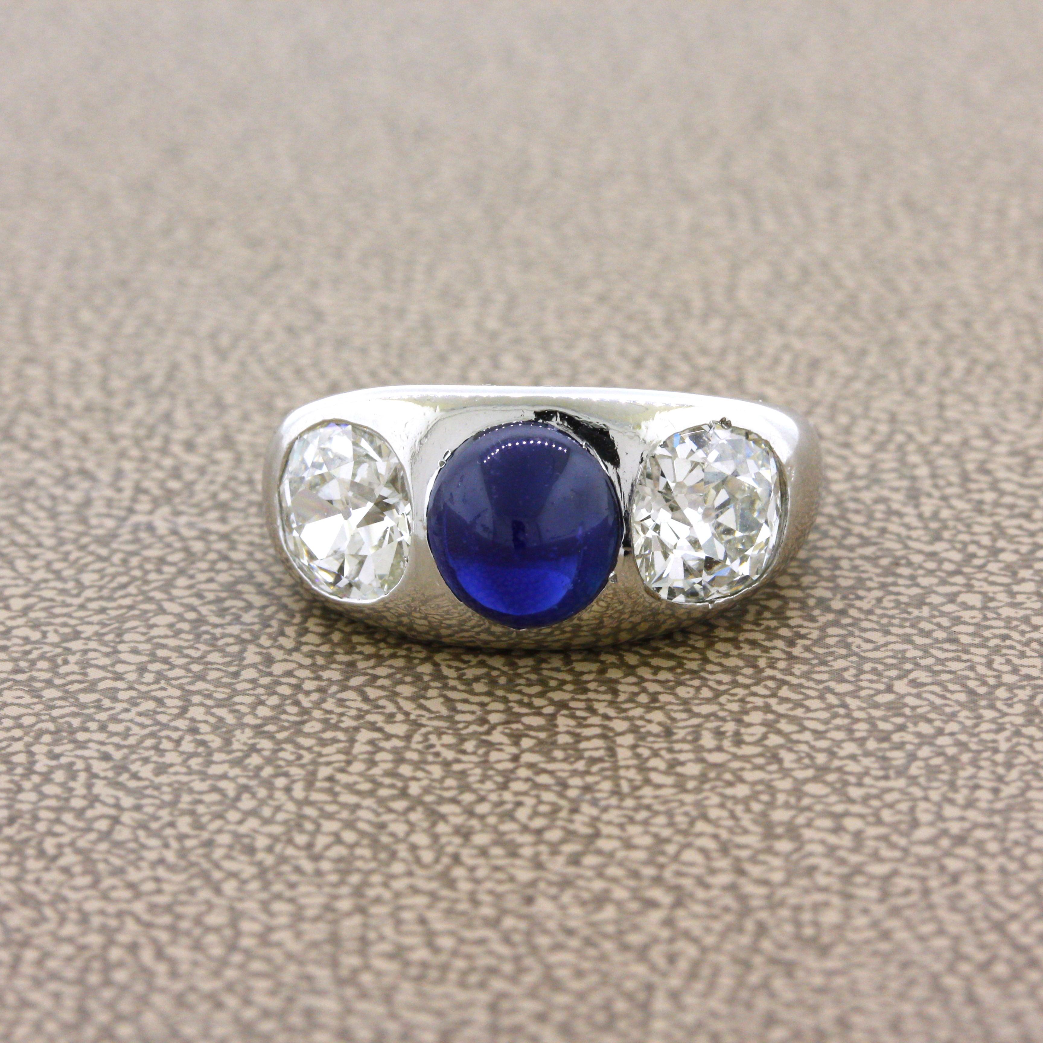 A lovely modern made ring designed in the antique style. It features a cabochon sapphire, certified by the AGL, in its center along with two large old European-cut diamonds set on its sides. The two diamonds are the real stars of the show as they