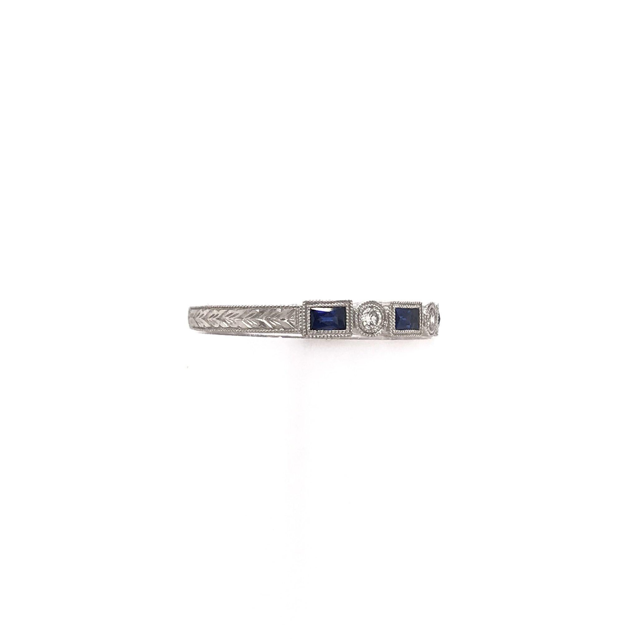 This piece is an extraordinary antique reproduction, meant to emulate the Art Deco design style. This platinum band features three sparkling diamonds accents as well as four french cut deep blue sapphires, extensive hand engravings, and fine