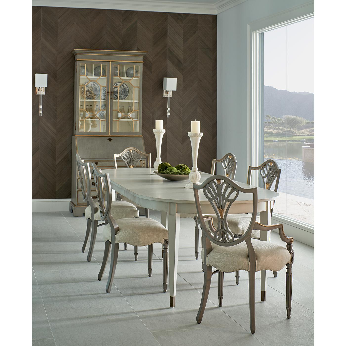 Caratterizzata da uno schienale a scudo graziosamente dipinto in una sofisticata finitura grigio Buckingham, accentuata da dettagli dorati, questa sedia porta un tocco di fascino storico in qualsiasi spazio da pranzo. La cornice intricatamente
