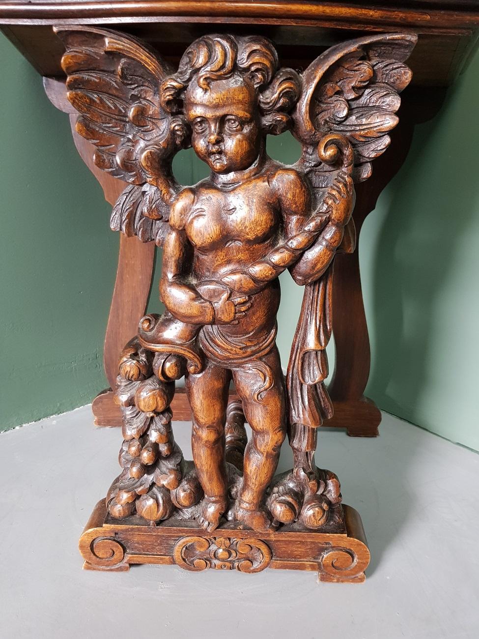 Antique style Italian Renaissance Revival hall table with a carved angel on the front surrounded by flowers, garland, etc. (the blade has slight traces of users), from the First half of the 20th century.

The measurements are,
Depth 36 cm/ 14.1